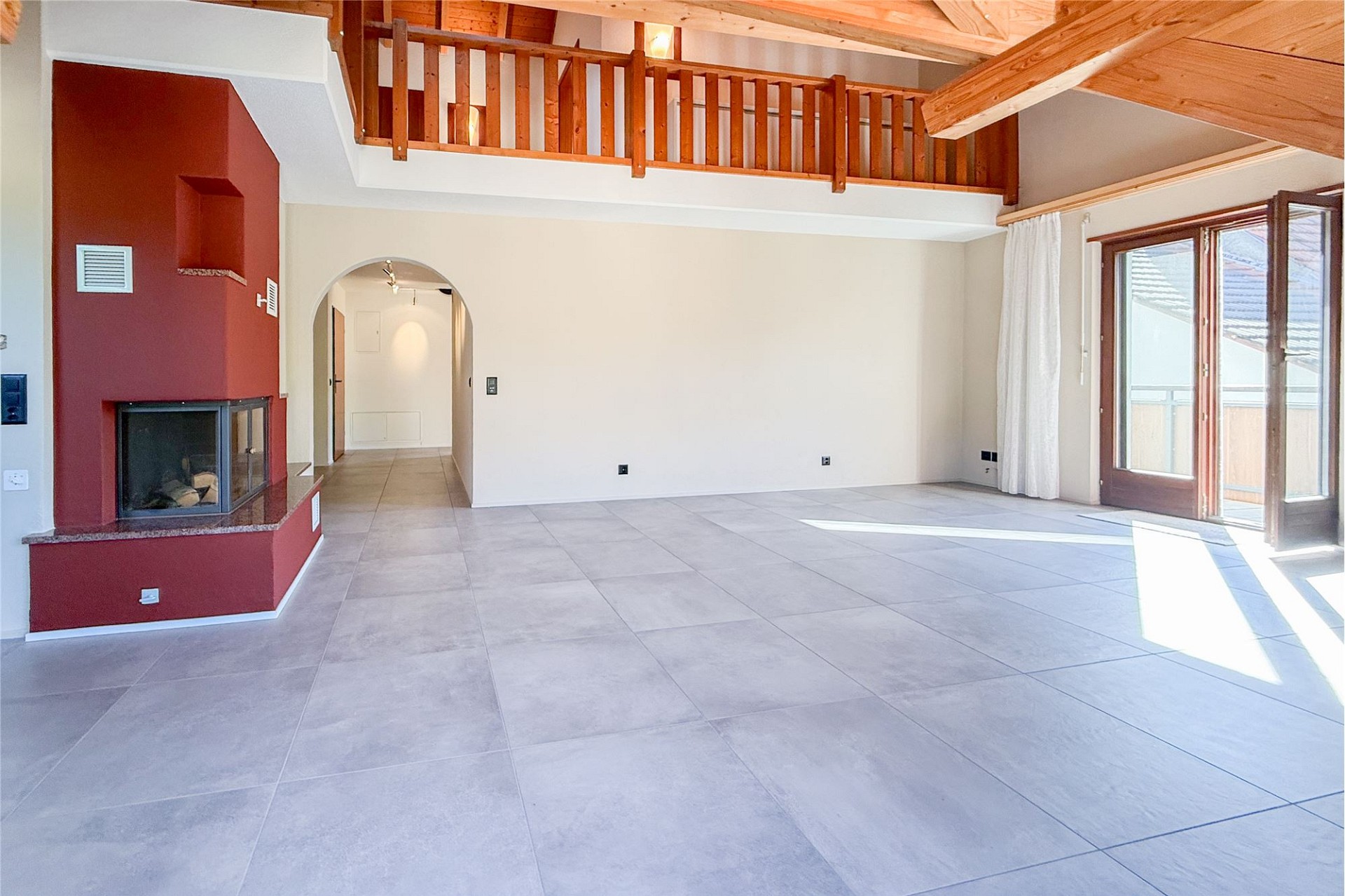 Großer Wohnraum mit Kamin und Galerie