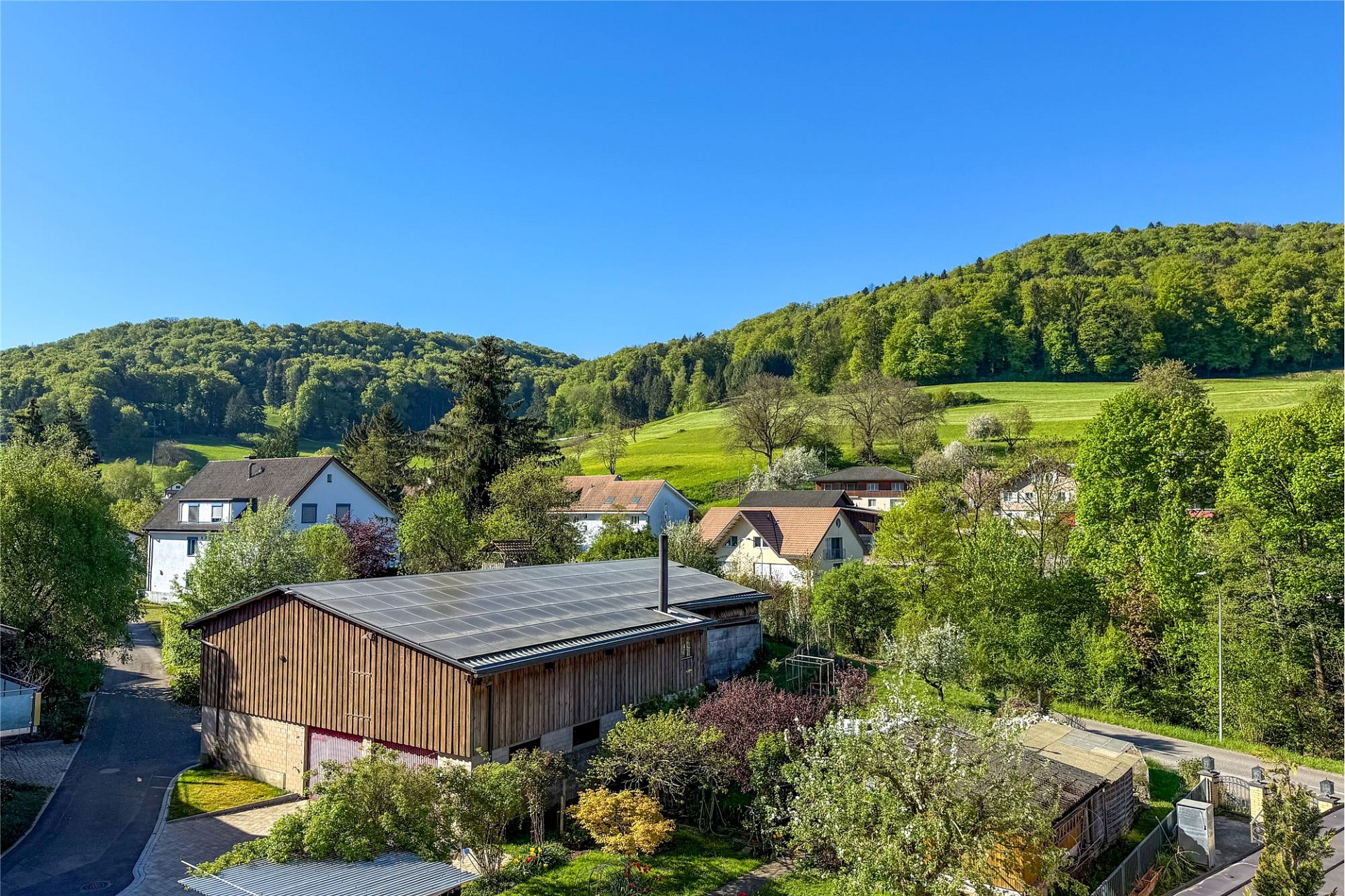 Ländliche Wohngegend mit Wiesen und Hügelblick