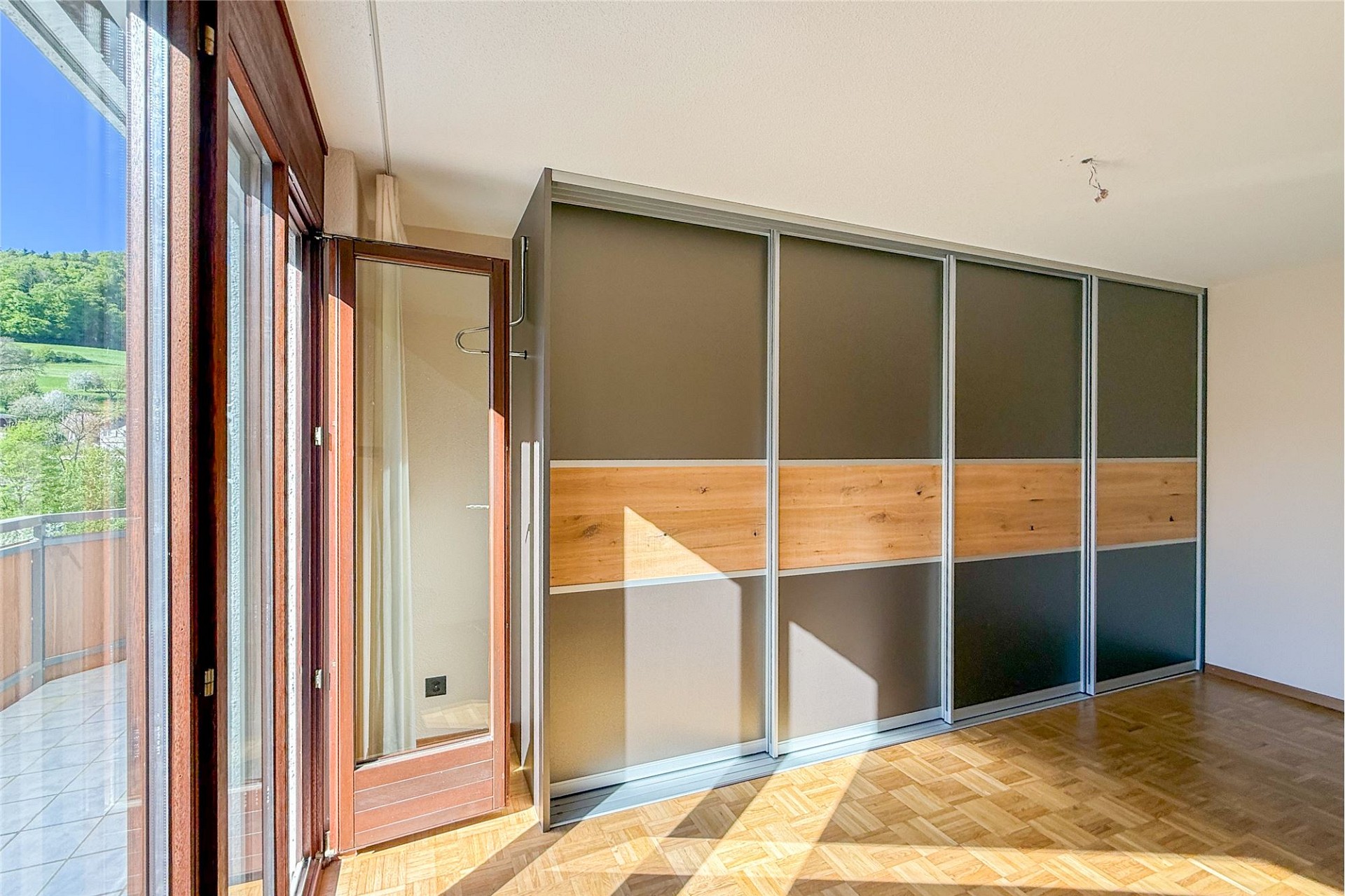 Helles Schlafzimmer mit Balkonzugang und großem Kleiderschrank