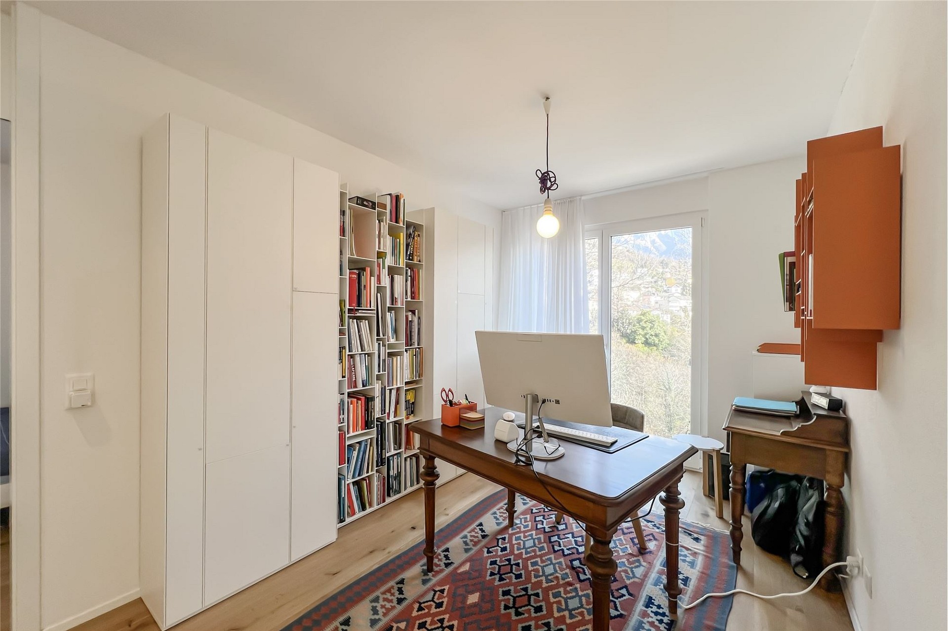Helles Arbeitszimmer mit Schreibtisch und Bücherregalen