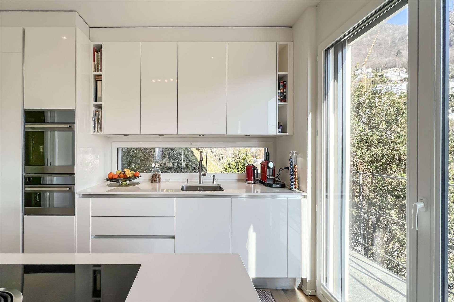 Moderne, helle Küche mit großen Fenstern