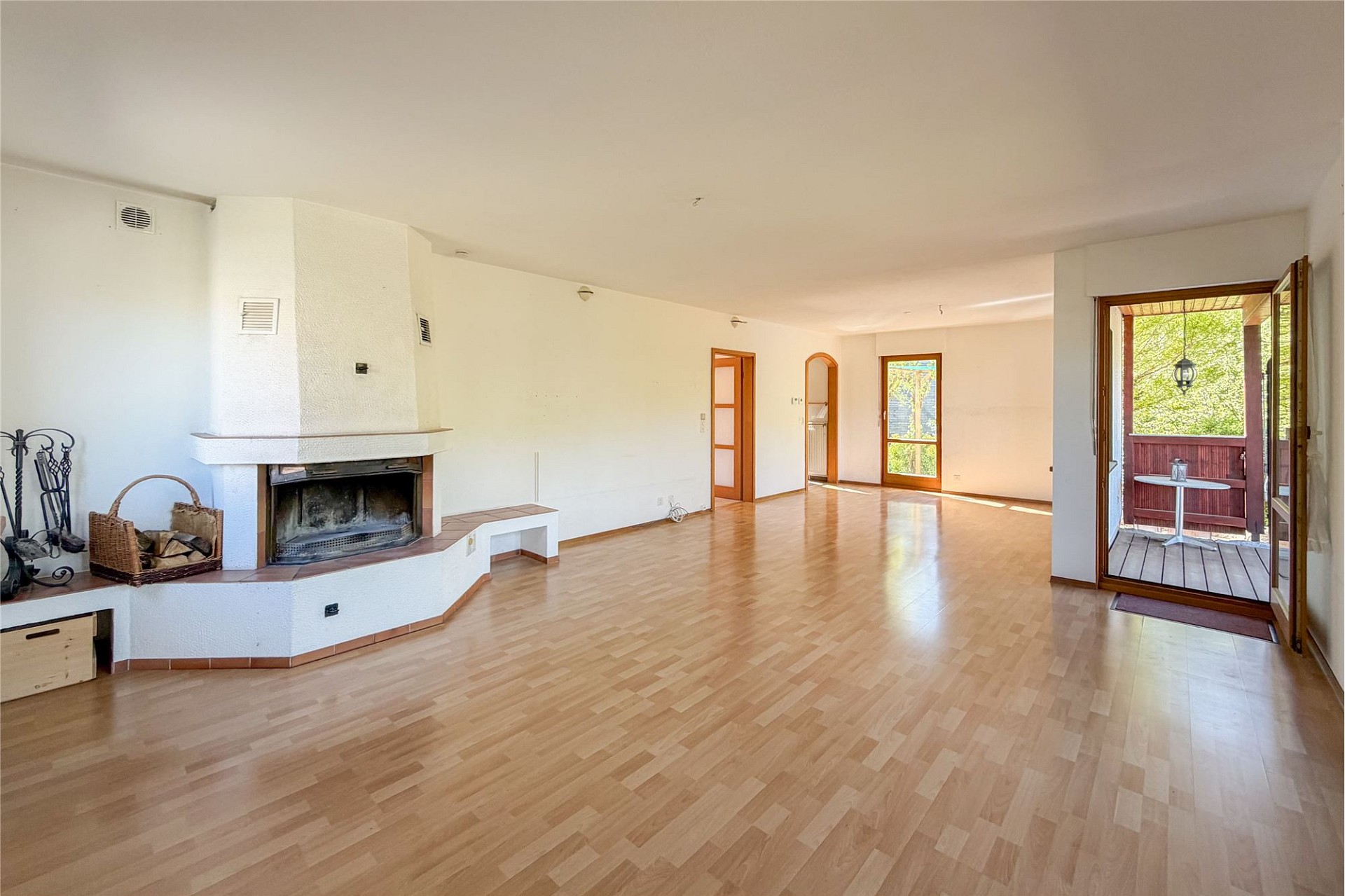 Großer Wohnraum mit Kamin und Zugang zur Terrasse