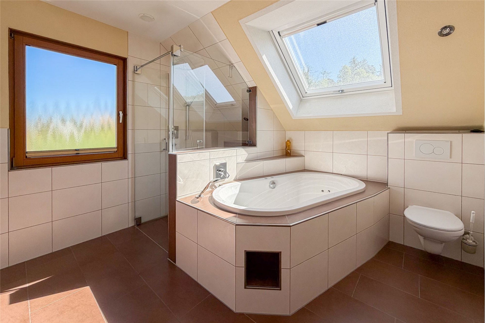 Helles Badezimmer mit Dachfenster und Badewanne