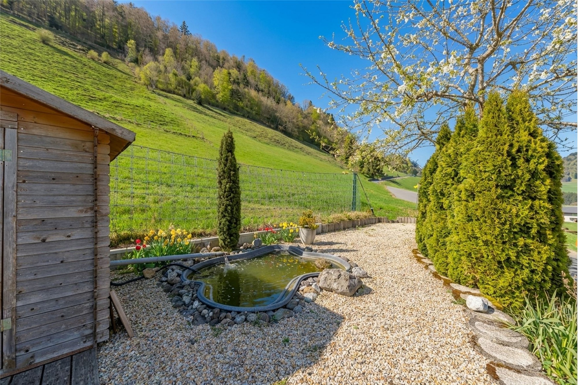 Ländlicher Garten mit Teich und Hanglage