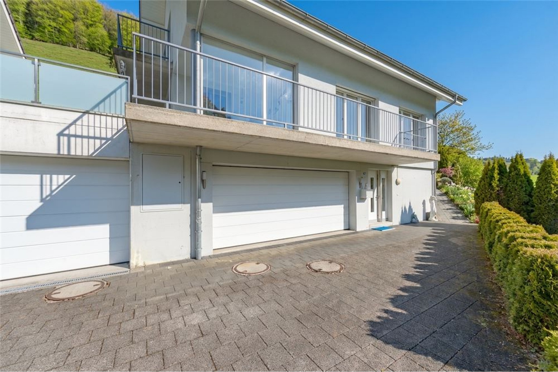 Moderne Hausfassade mit Doppelgarage und Balkon