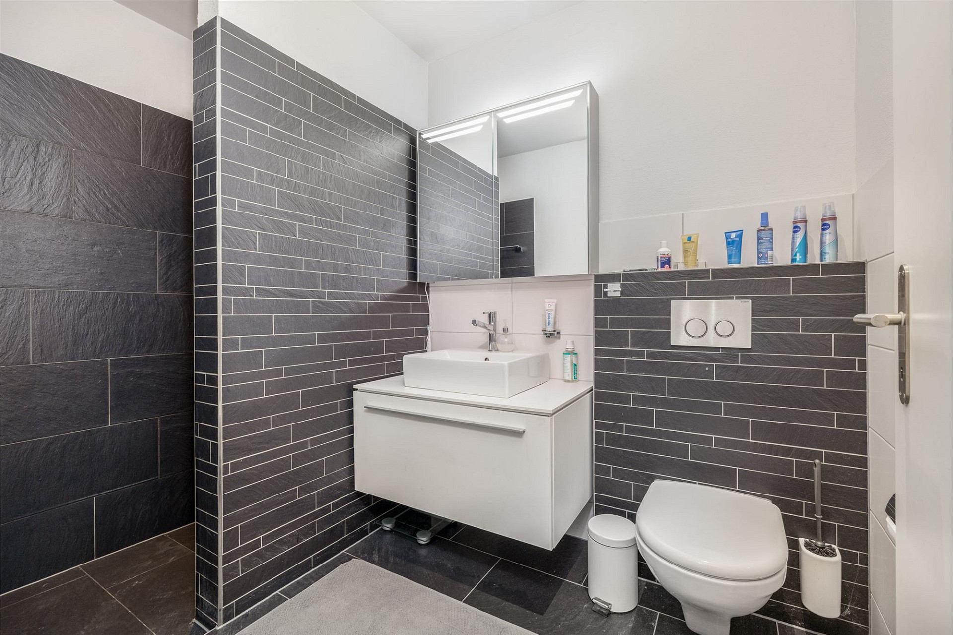 Modernes Gäste-WC mit dunkler Verkleidung