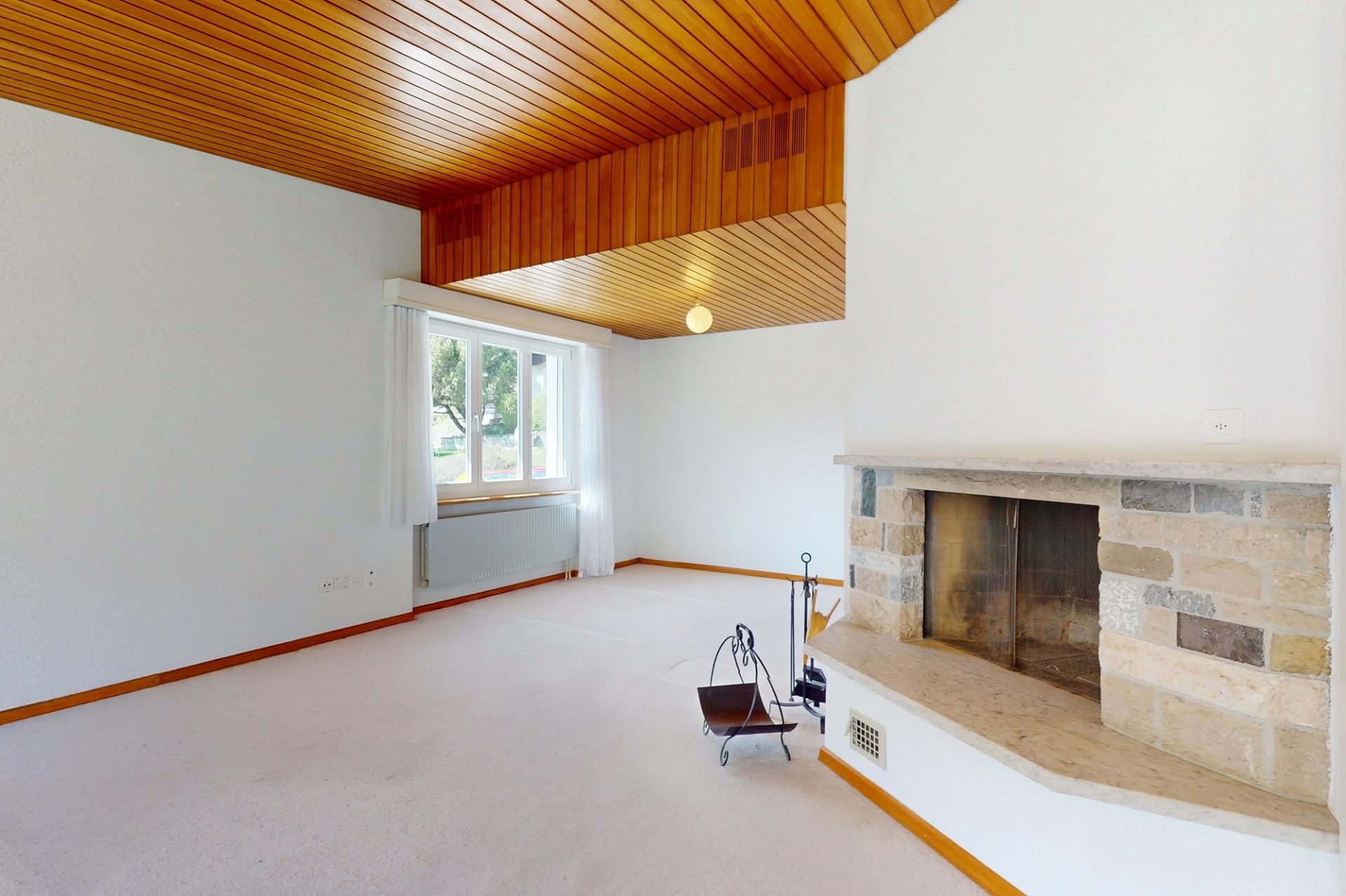 Wohnzimmer mit Kamin und Holzbalkendecke