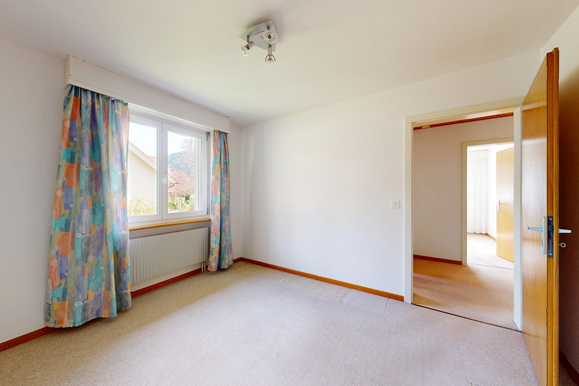 Helles, einfaches Zimmer mit Fenster und Durchgang
