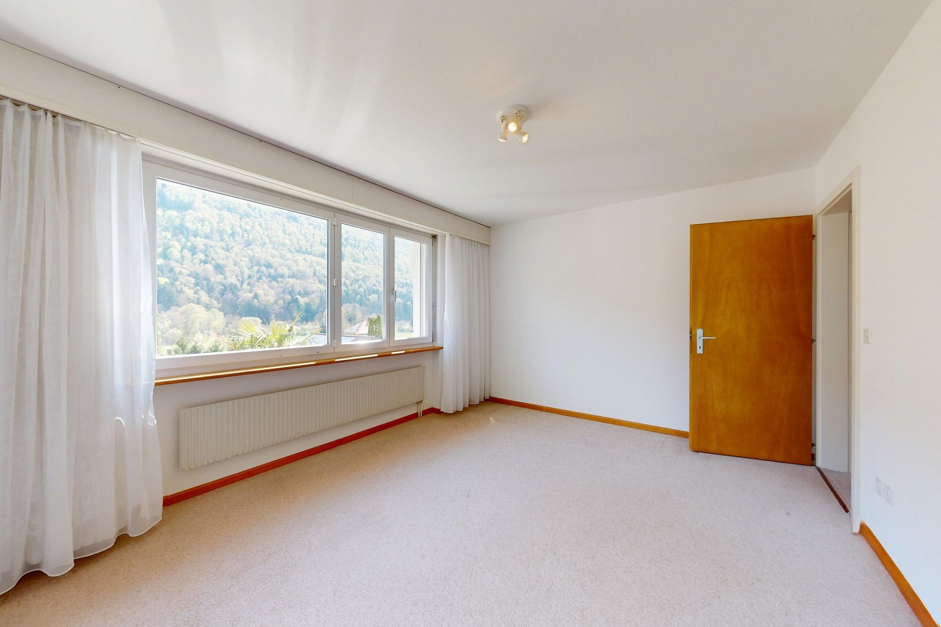 Helles, leeres Schlafzimmer mit Bergblick