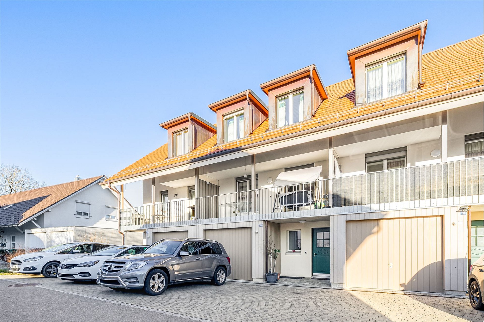 Mehrfamilienhaus mit Dachgauben und Stellplätzen