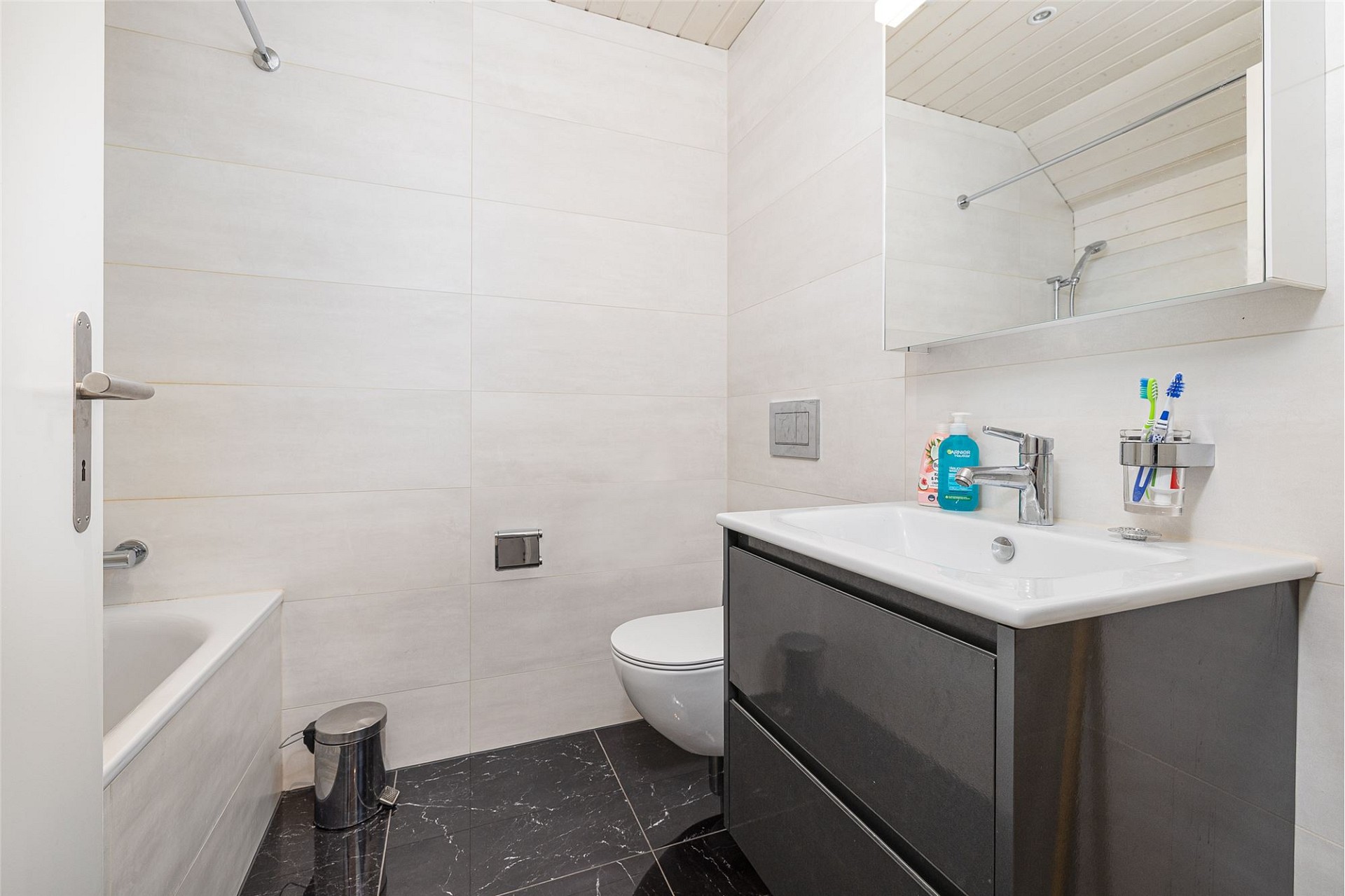 Kleines modernes Badezimmer mit Badewanne, WC und Waschtisch