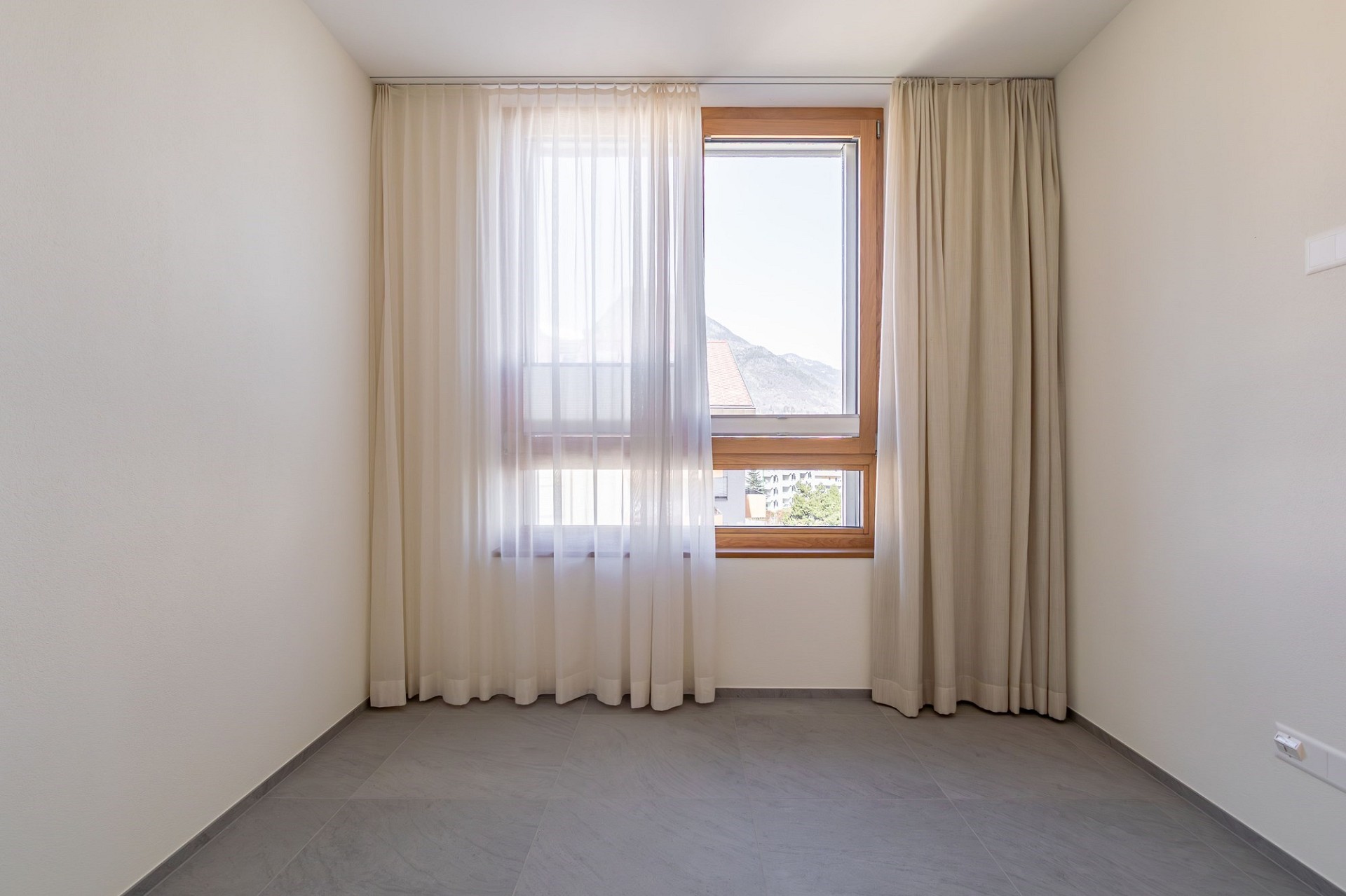 Leeres Zimmer mit Fenster und Vorhängen