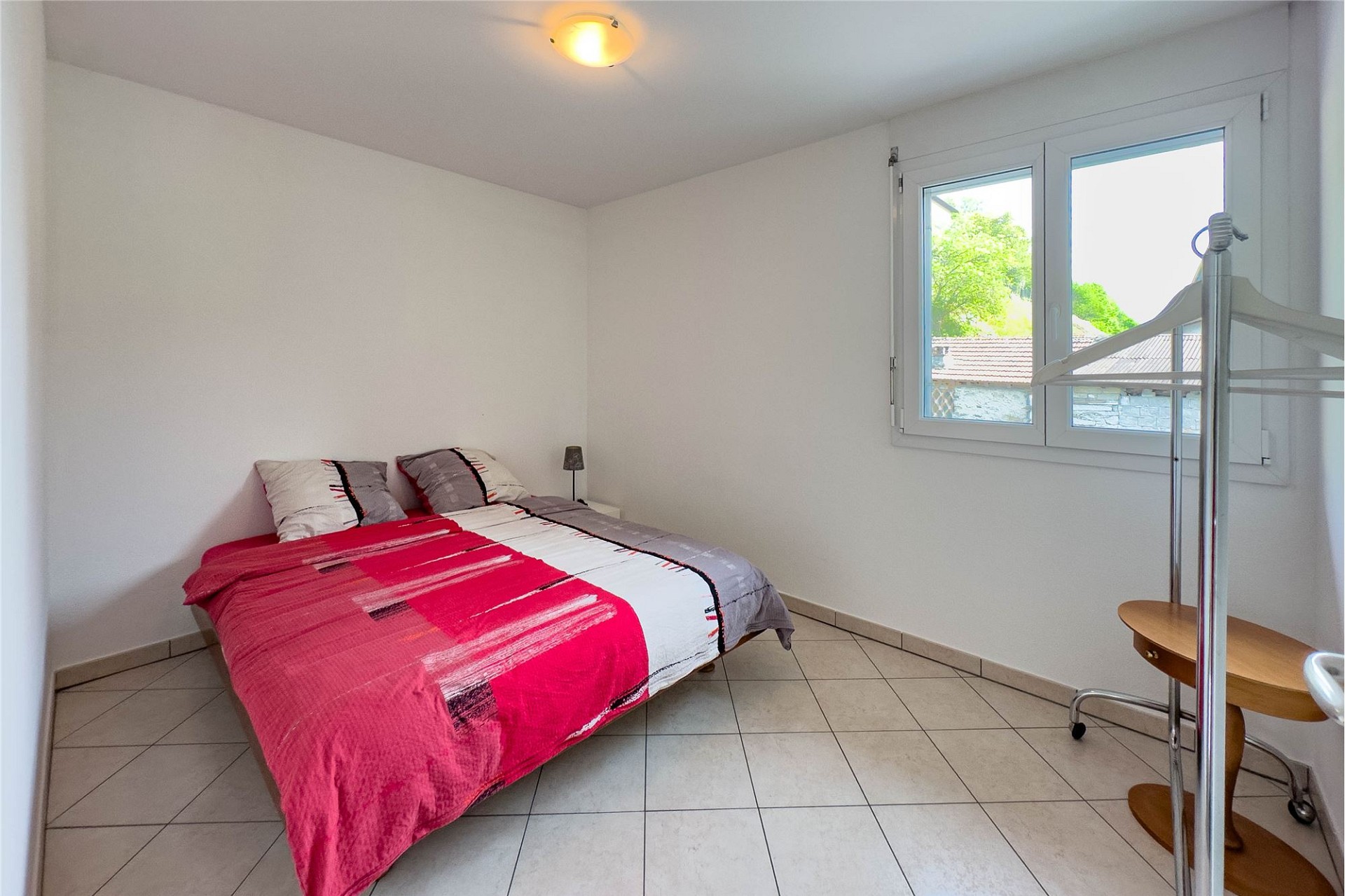 Helles Schlafzimmer mit roter Bettwäsche