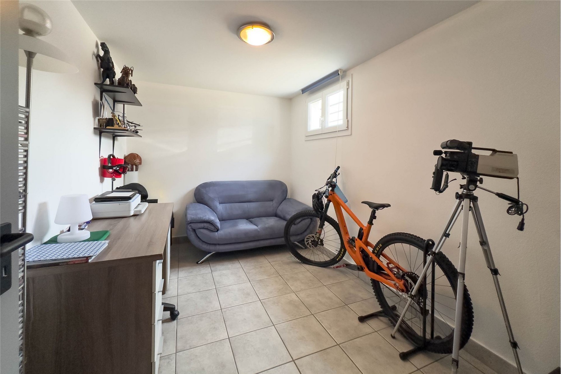 Kleines Arbeitszimmer mit Fahrrad und Kameraausrüstung