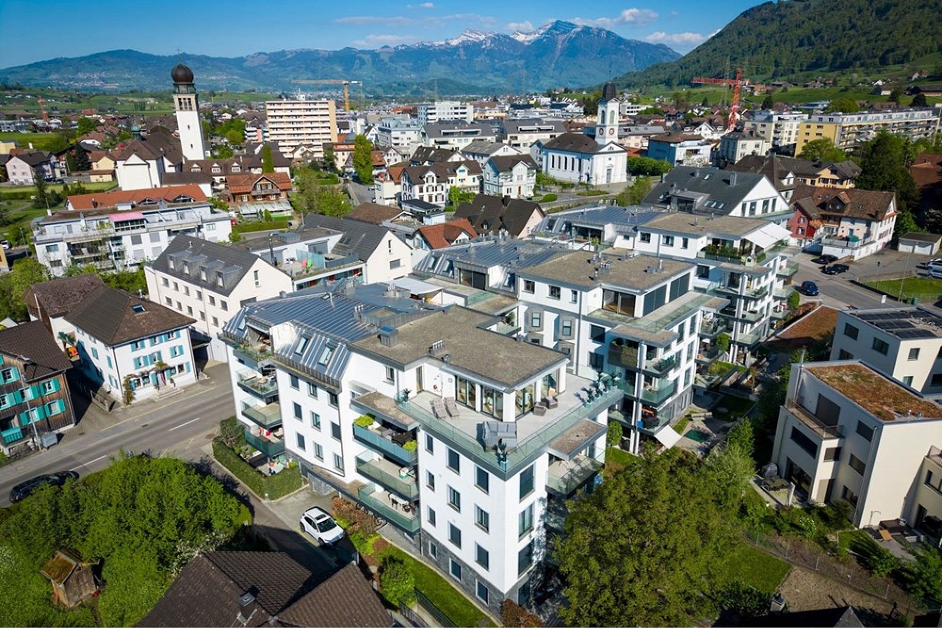 Luftaufnahme eines Wohnquartiers mit Bergpanorama