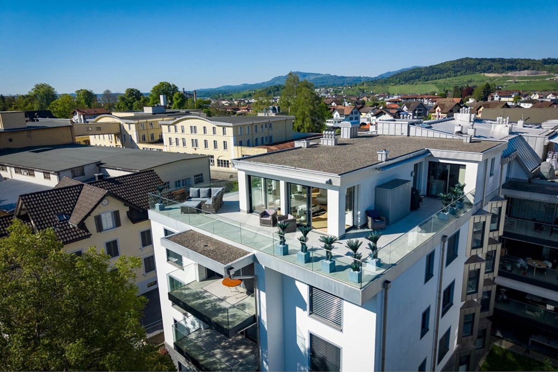 Drohnenaufnahme eines modernen Wohngebäudes mit Dachterrasse