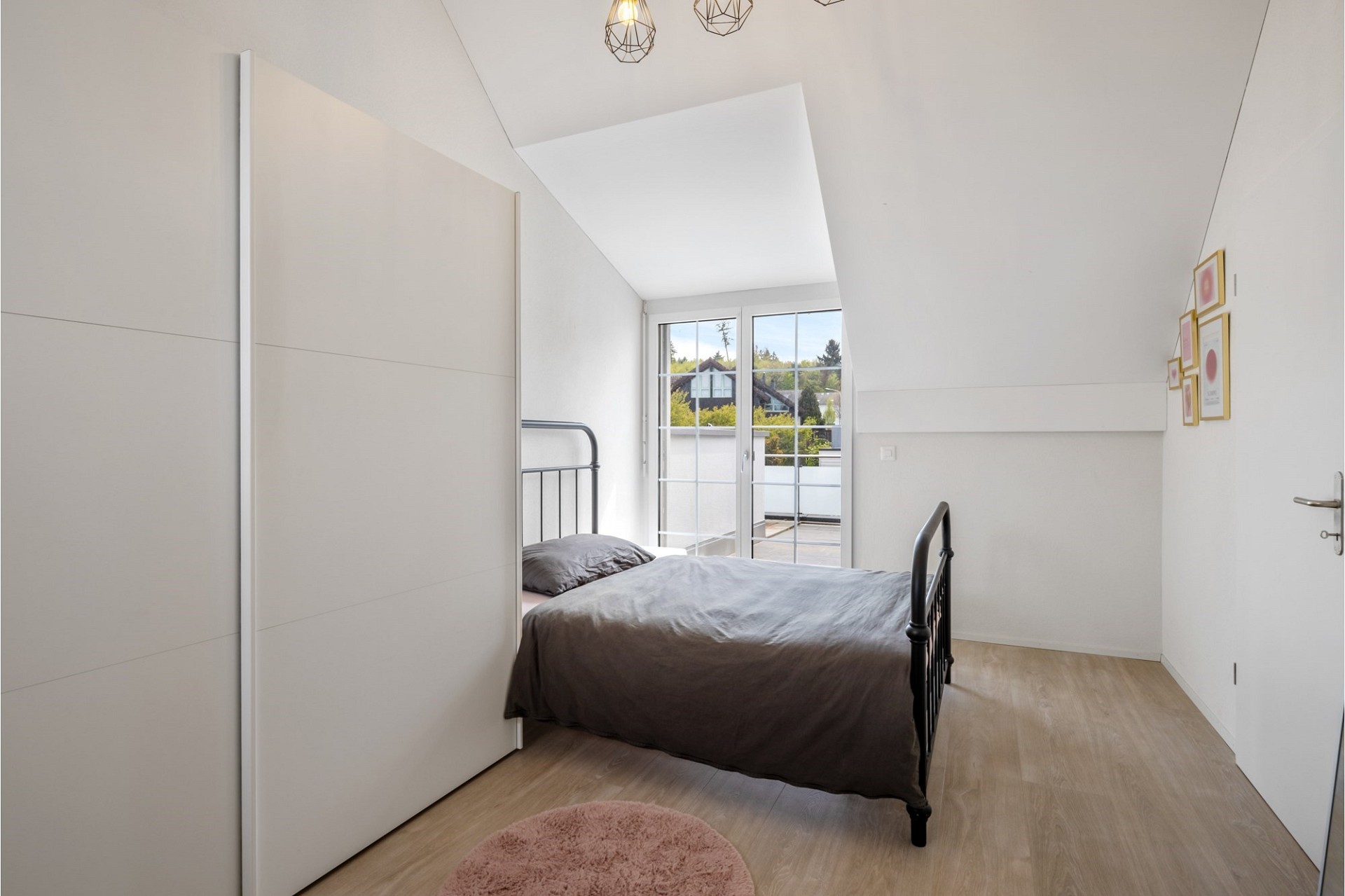 Helles Schlafzimmer mit Dachschräge und Balkontür
