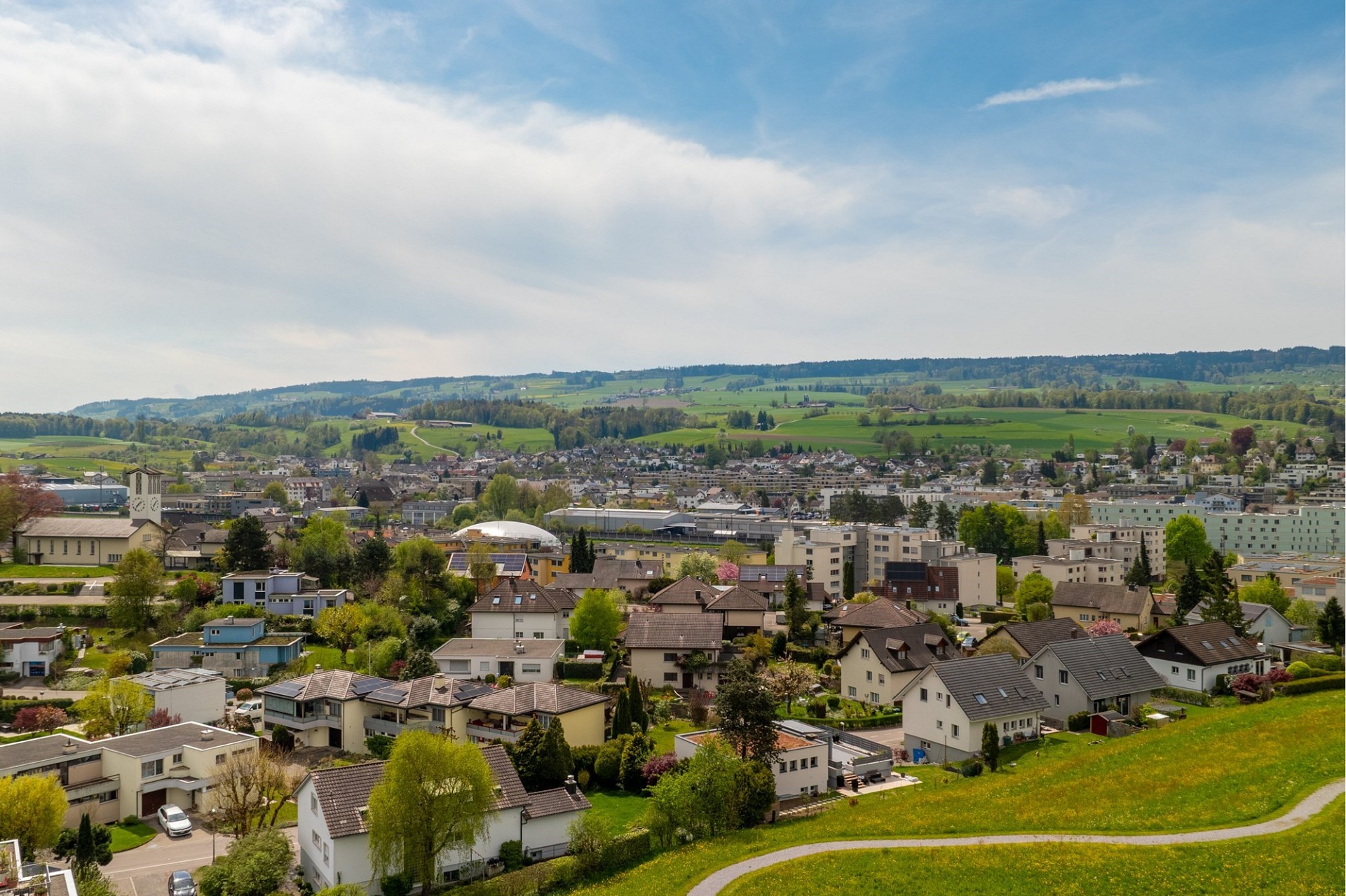Stadtpanorama mit grünen Hügeln