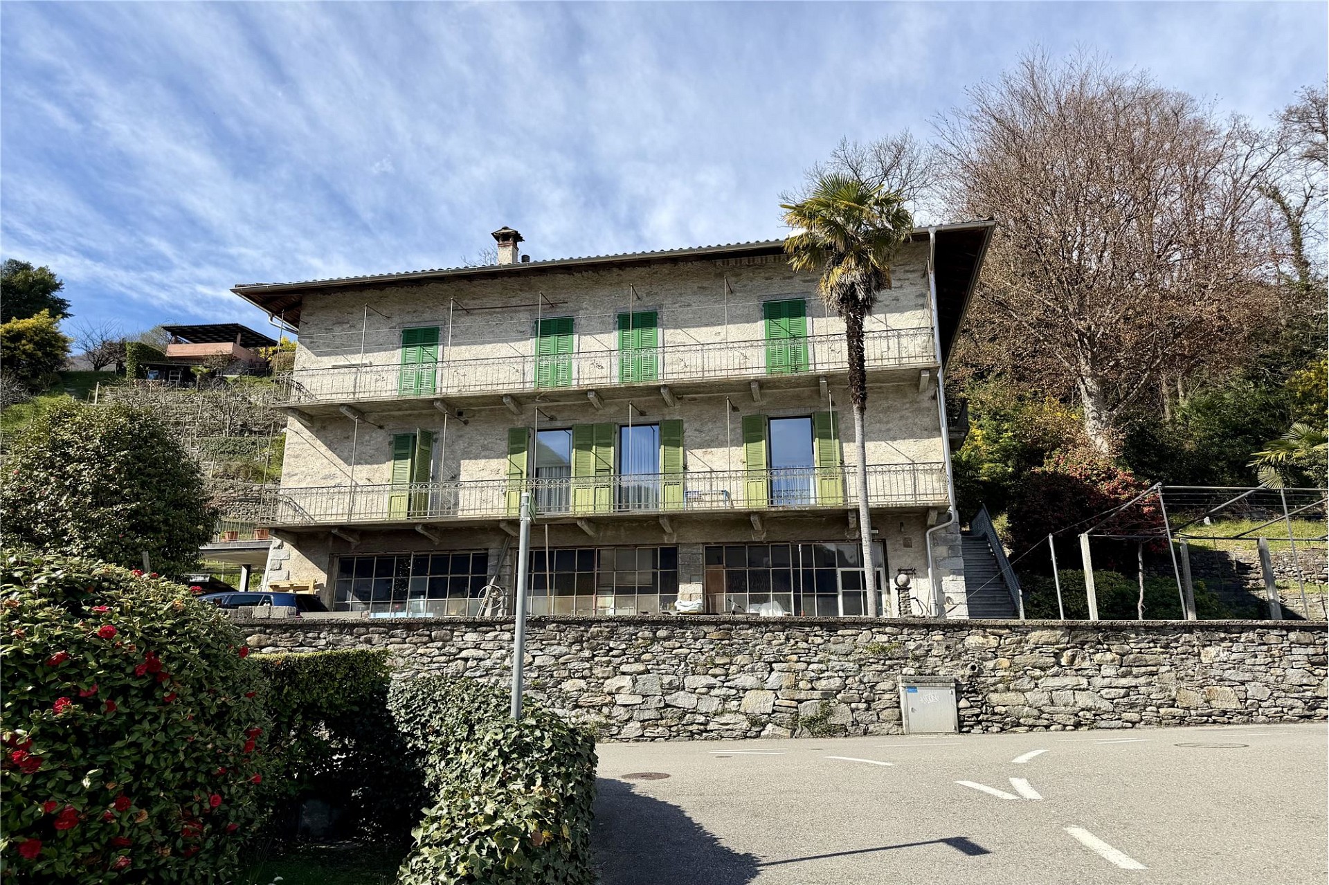 Historische Villa mit Balkonen und grünem Fensterläden