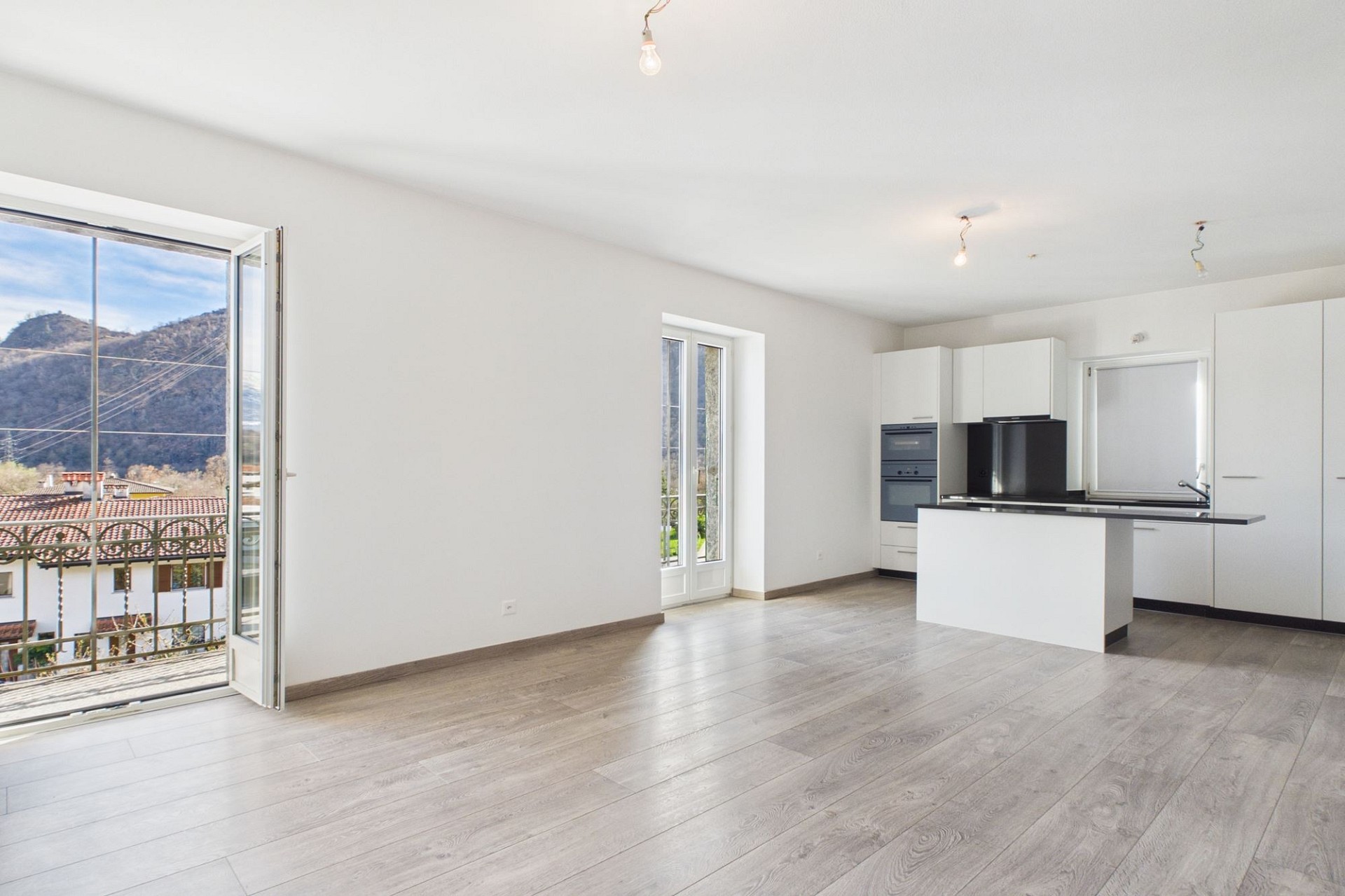 Heller Wohnraum mit offener Küche und Bergblick