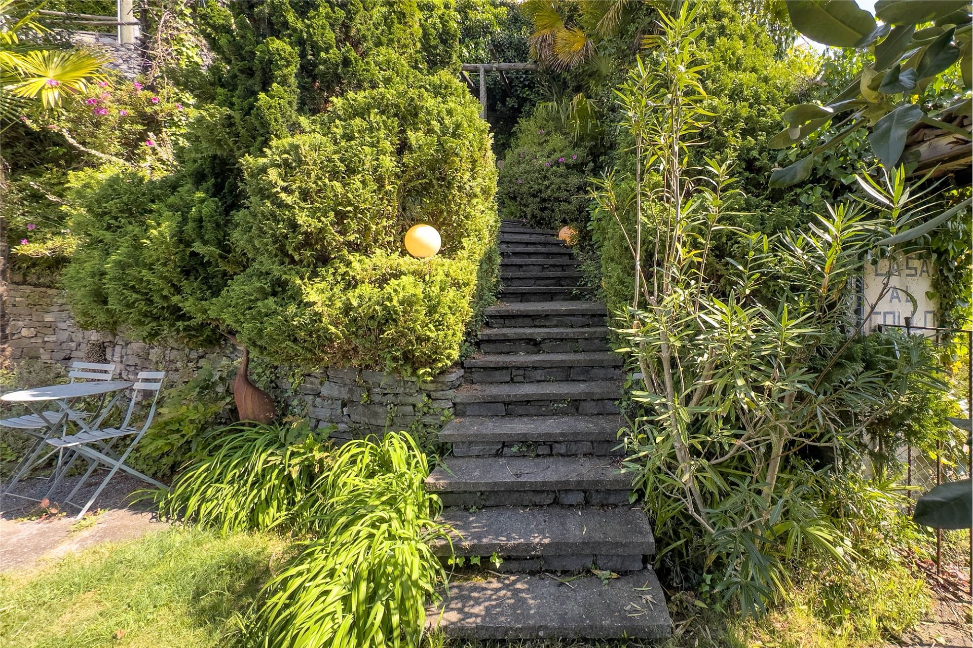 Üppiger Gartenzugang mit Steintreppe