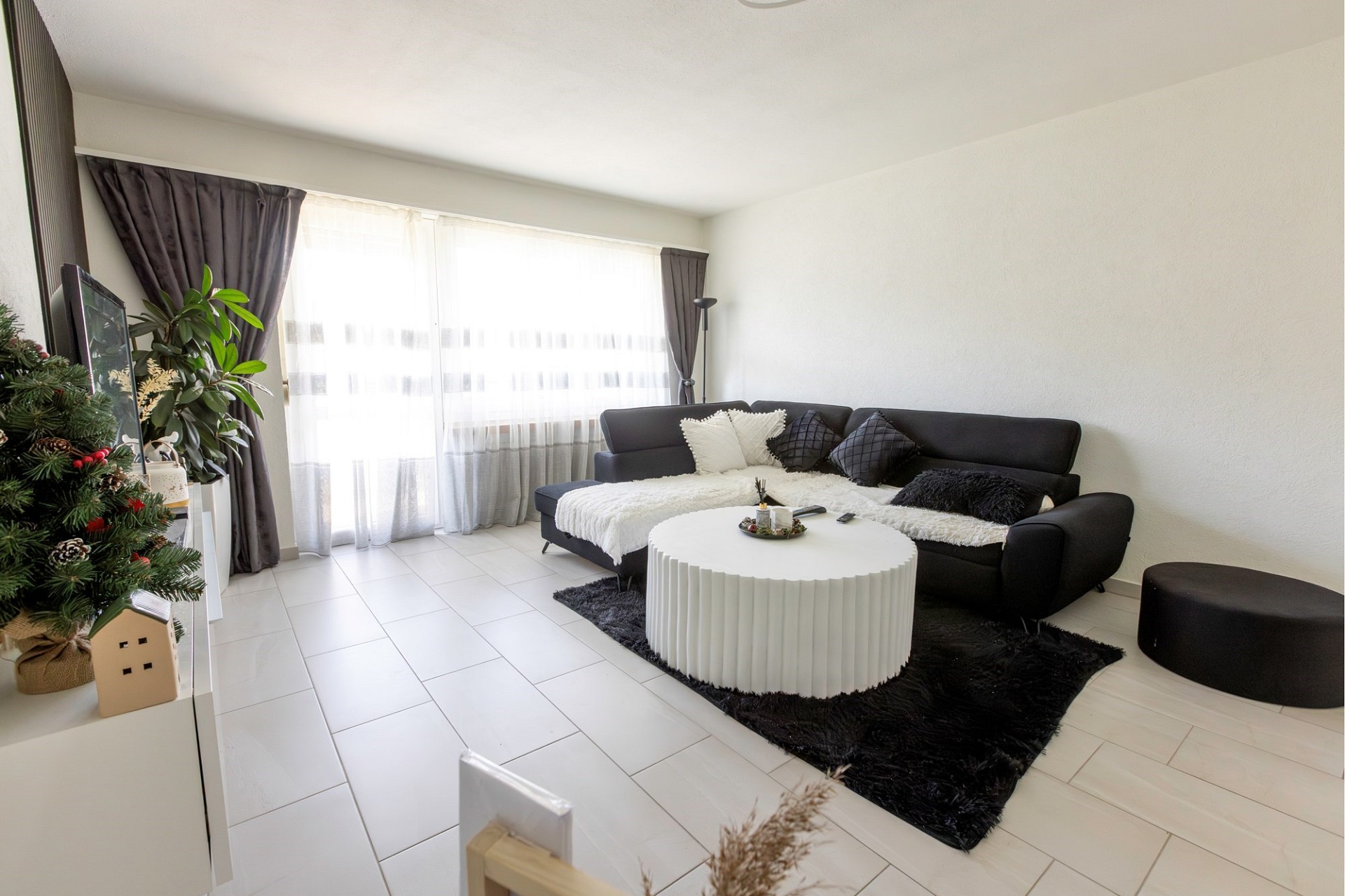 Helles Wohnzimmer mit schwarzer Couch