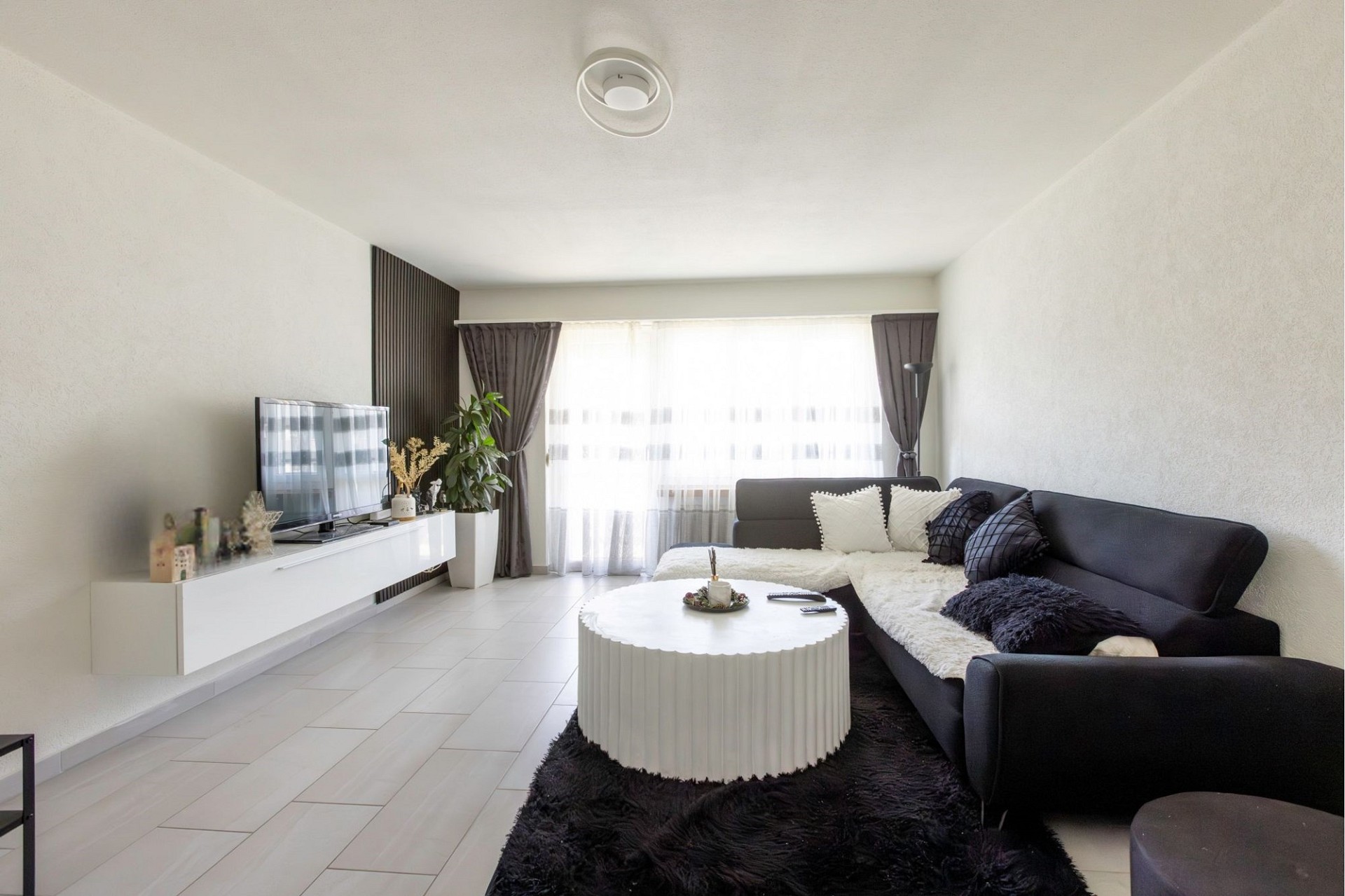Helles Wohnzimmer mit Sofa und TV