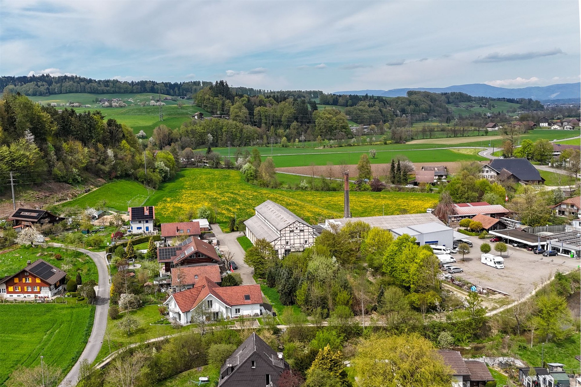 Luftaufnahme einer ländlichen Siedlung mit Feldern und Bergen