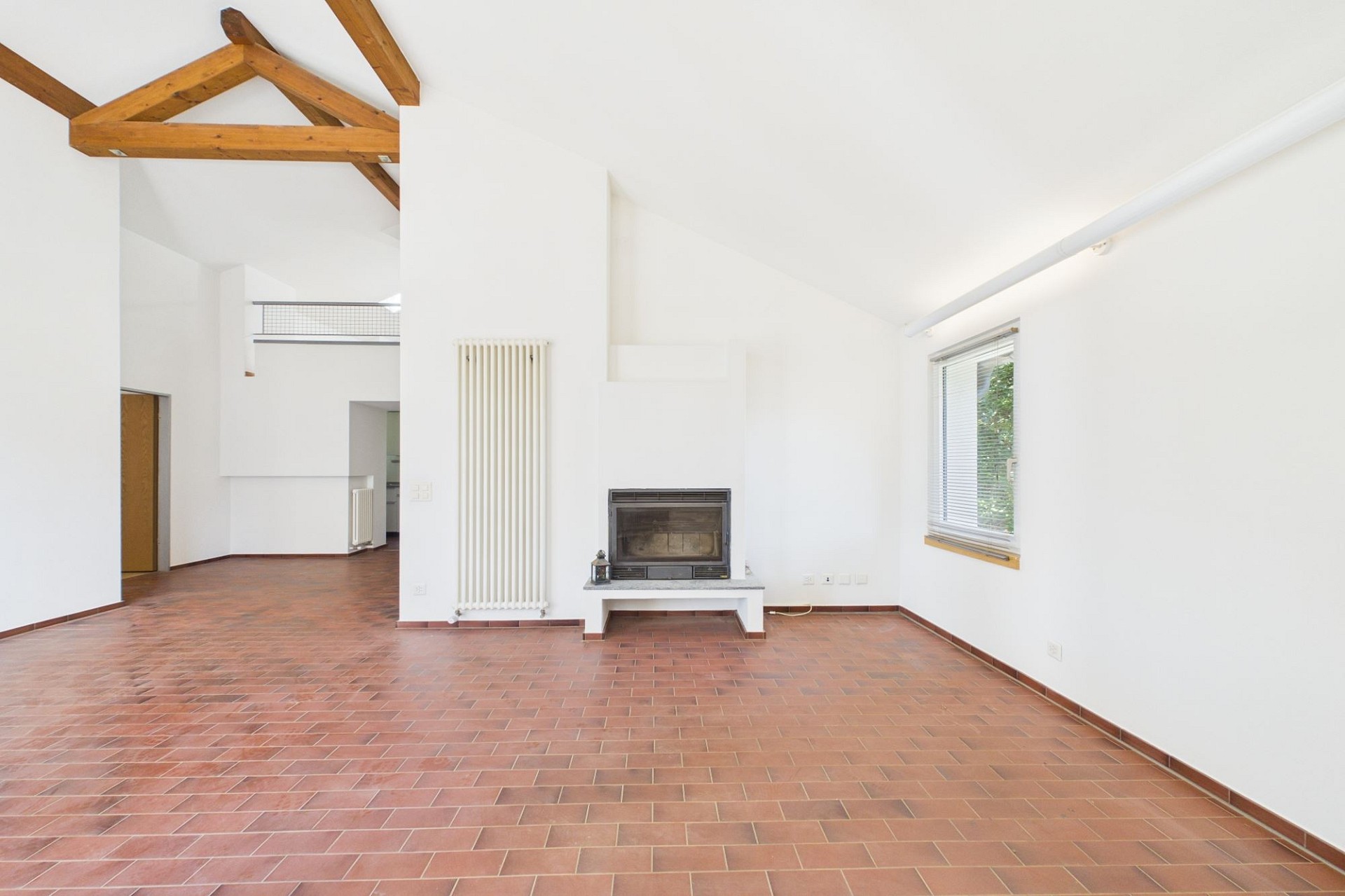 Heller Wohnraum mit Kamin und sichtbaren Holzbalken