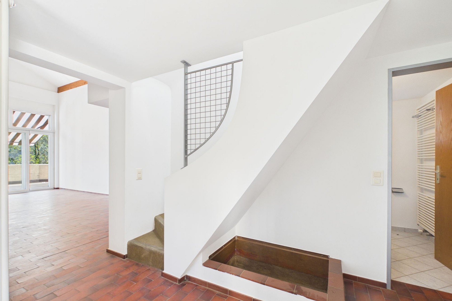Heller Flur mit Treppe und Blick in angrenzende Räume