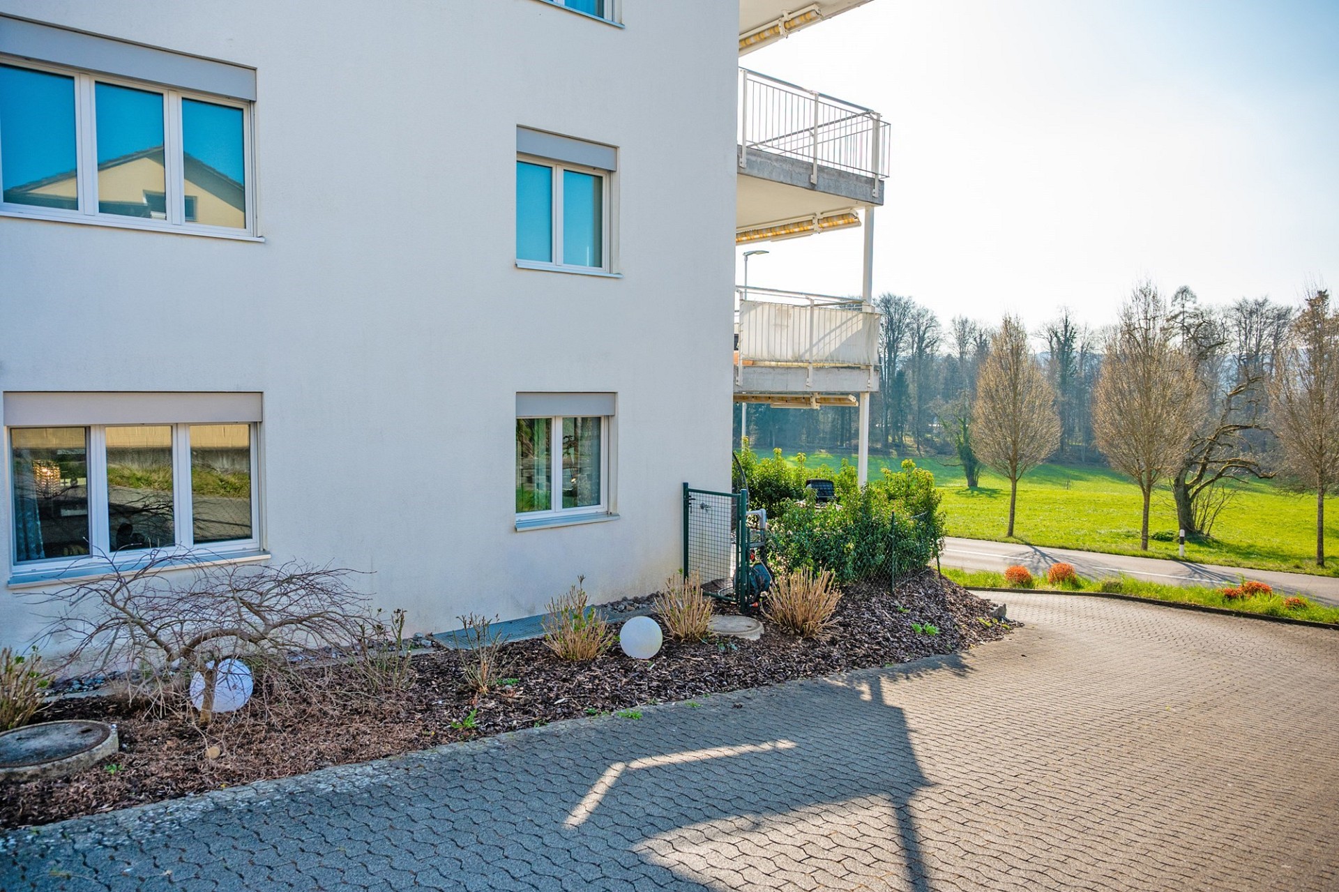 Außenansicht eines Wohngebäudes mit Balkon und Grünblick
