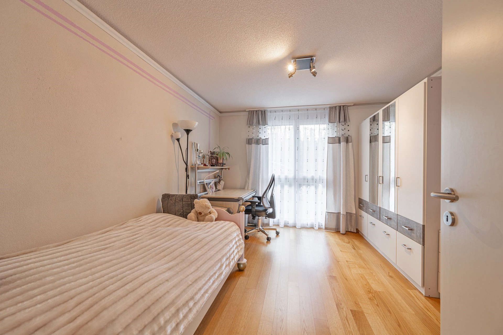 Helles Schlafzimmer mit Arbeitsplatz und Kleiderschrank