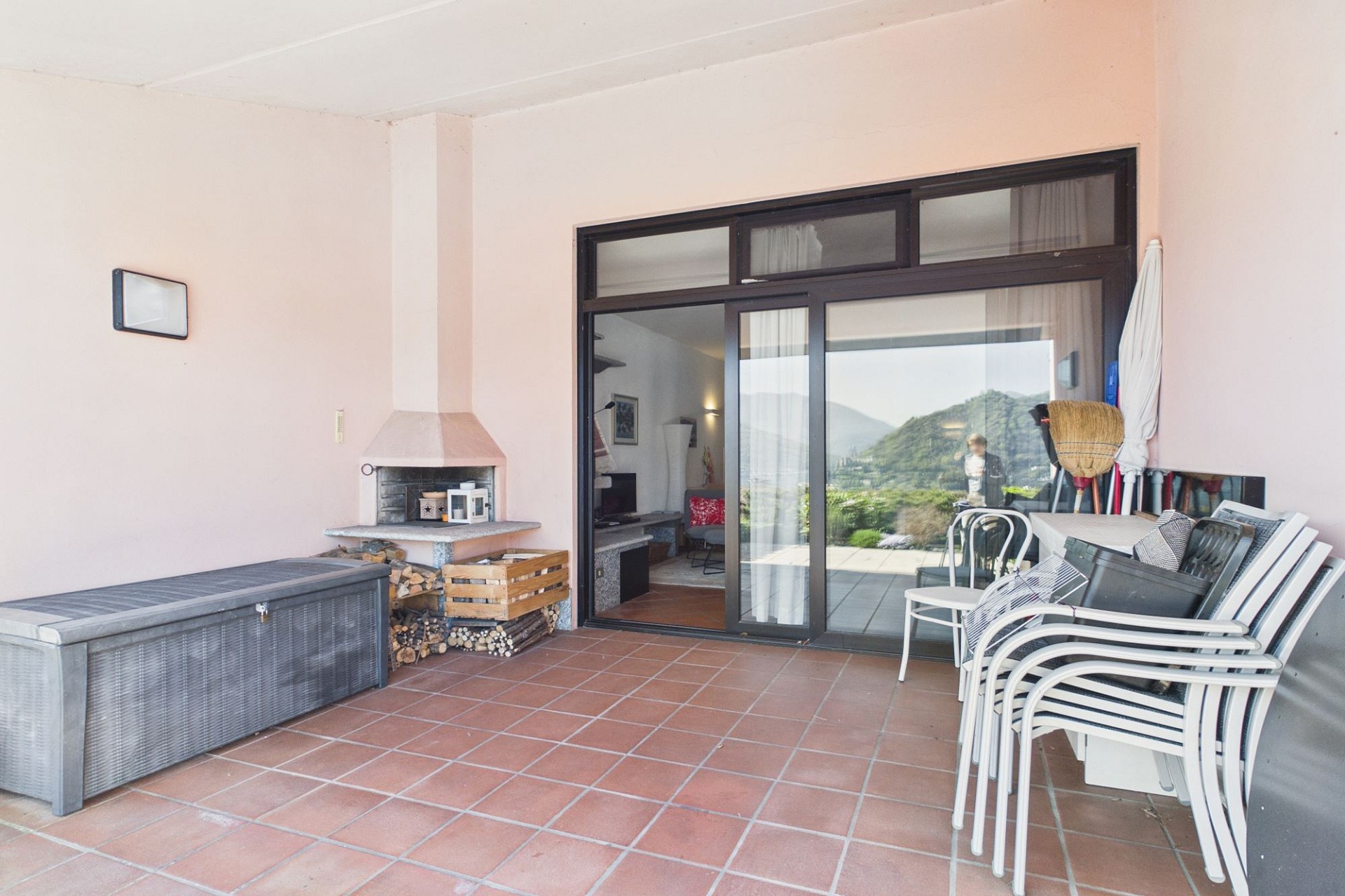 Überdachte Terrasse mit Sitzbereich und Kamin