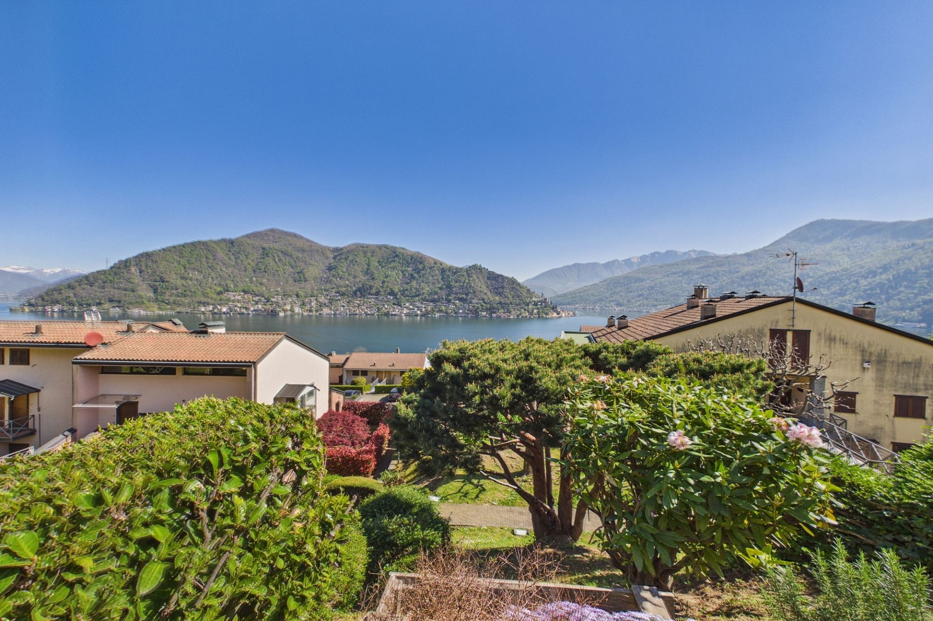 Seeblick mit Bergen und Wohnhäusern