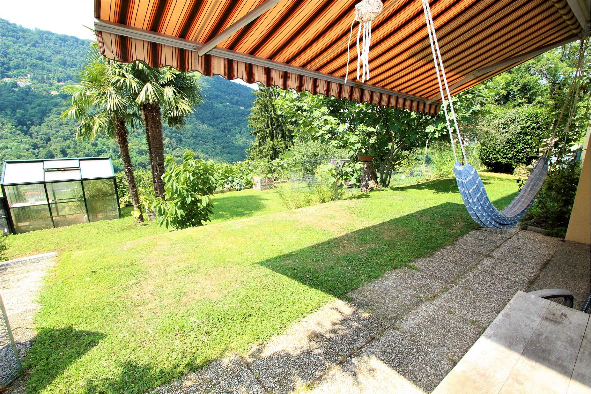 Überdachte Terrasse mit Gartenblick