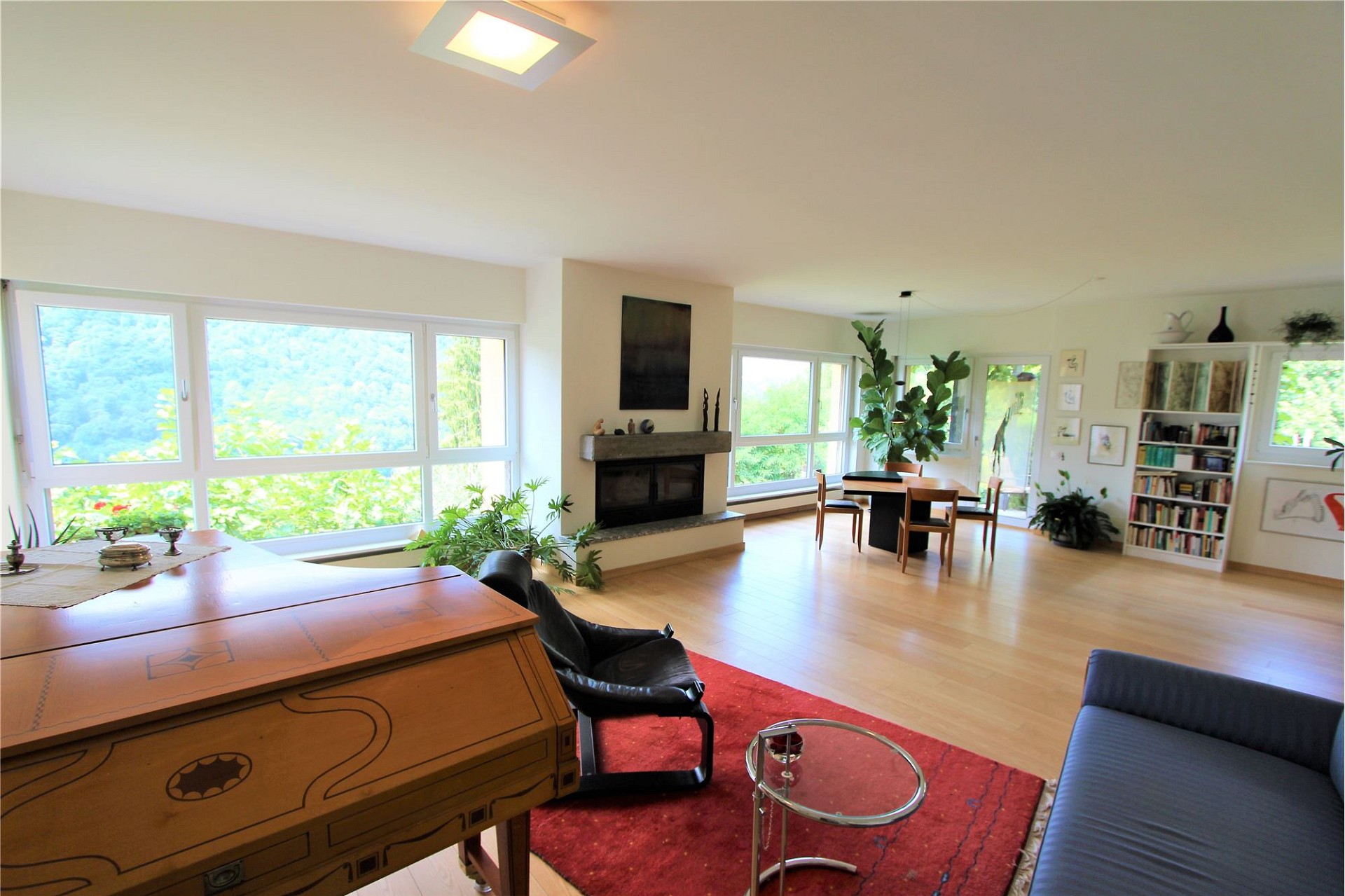 Helles Wohnzimmer mit großem Fensterband und Kamin