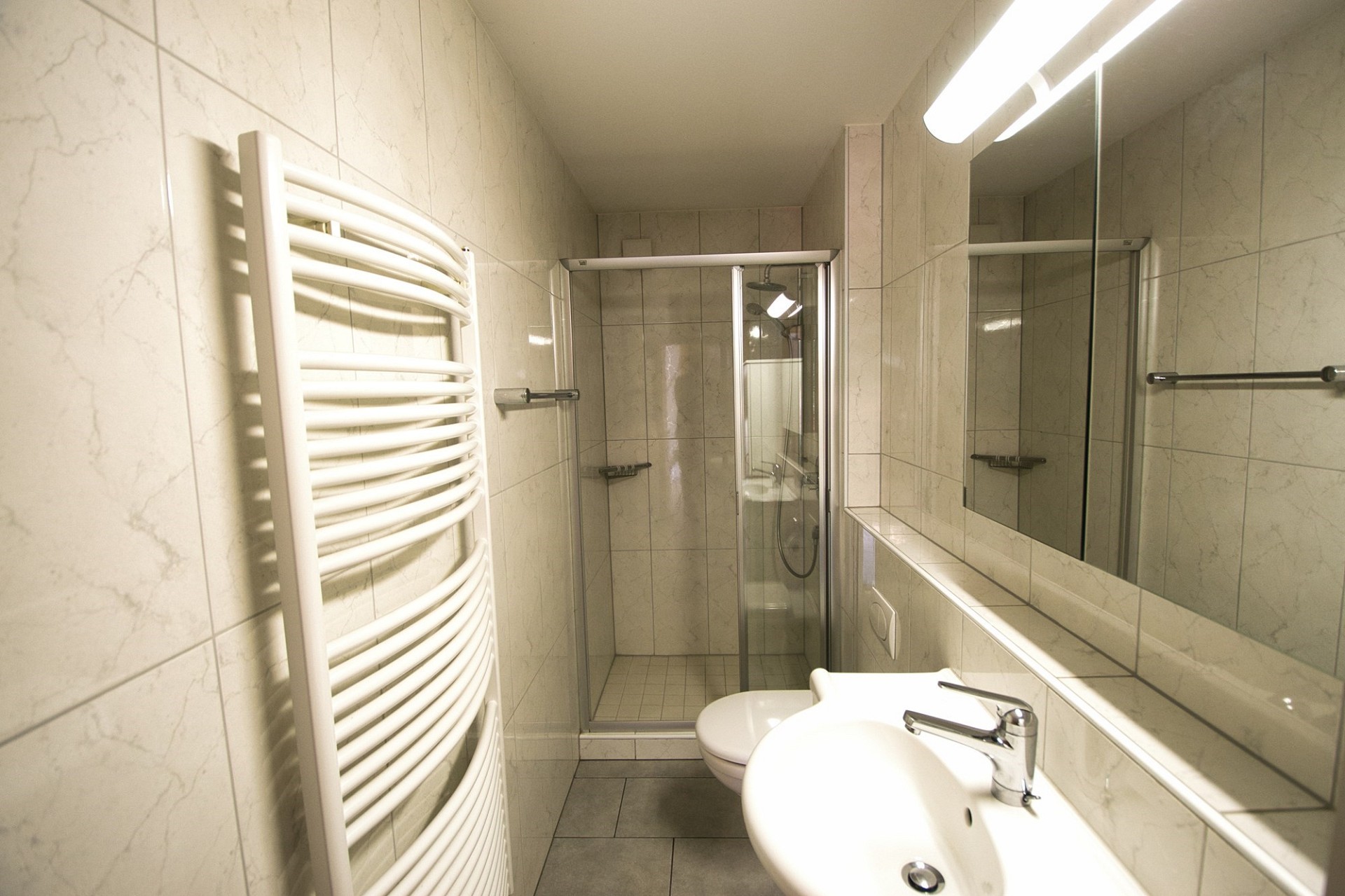 Modernes schmales Badezimmer mit Dusche und Doppelwaschbecken