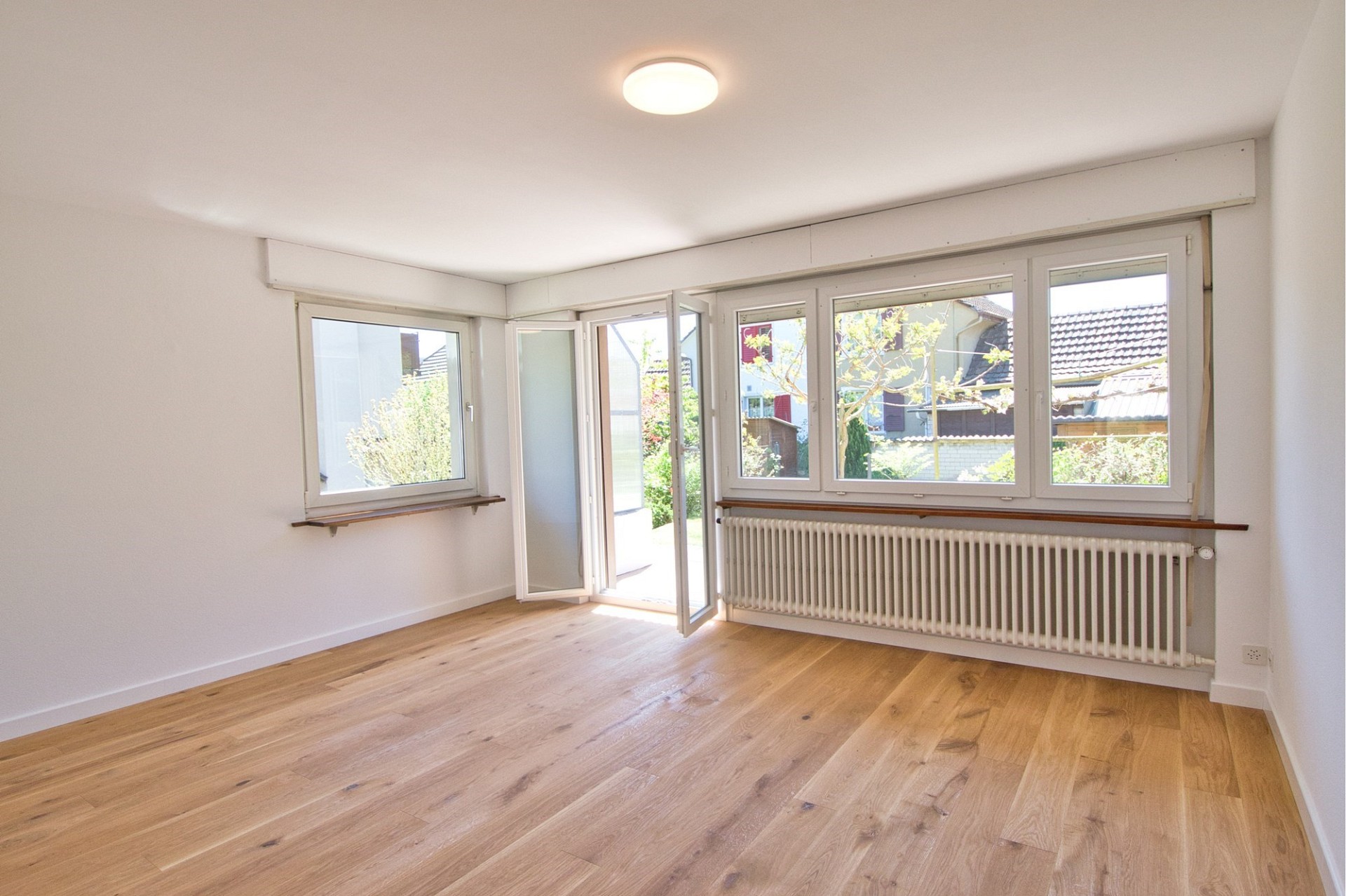 Heller leerer Wohnraum mit großen Fenstern
