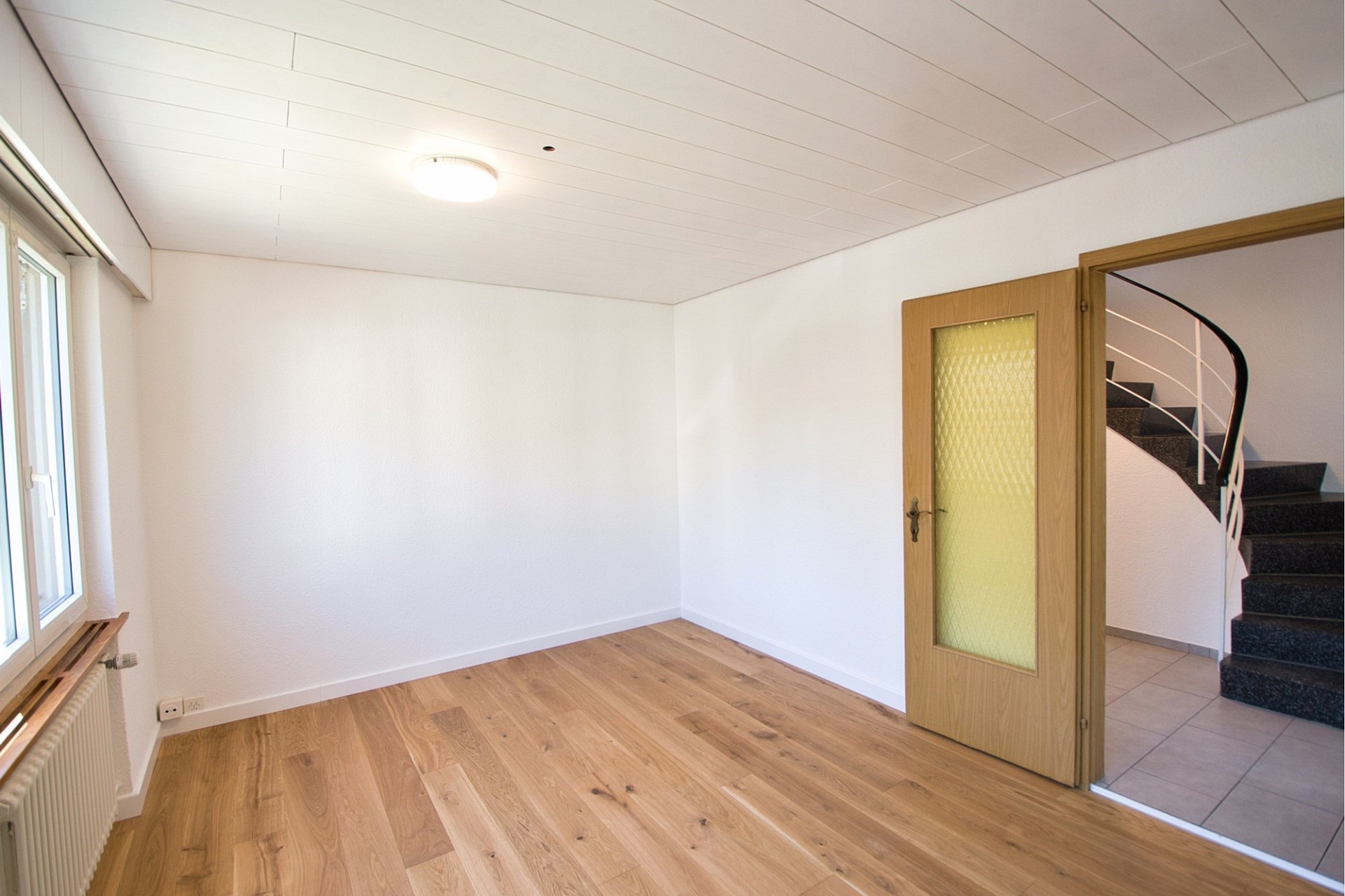 Heller Wohnraum mit Holzboden und Treppe