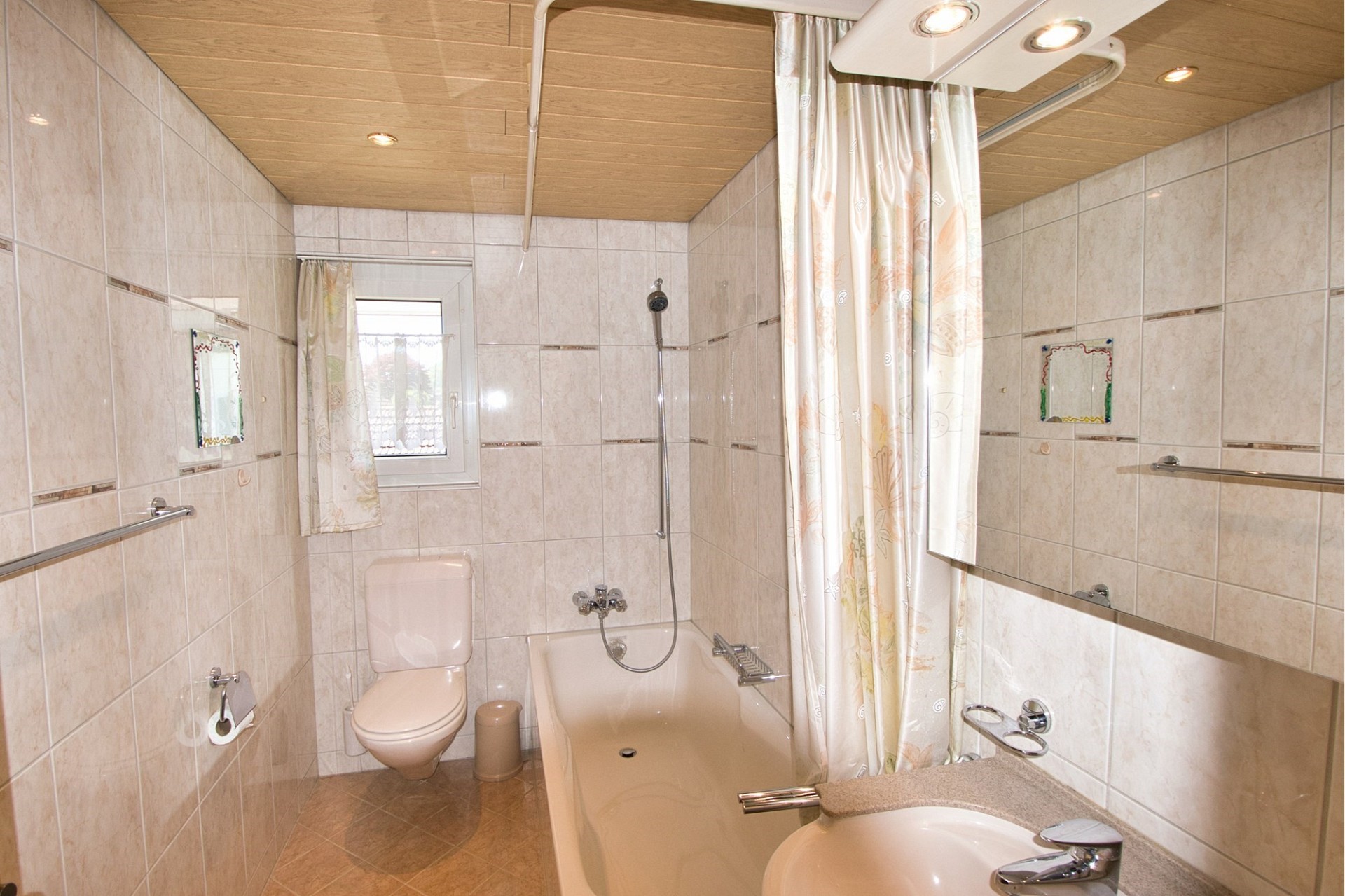 Innenansicht eines kleinen Badezimmers mit Wanne und Dusche