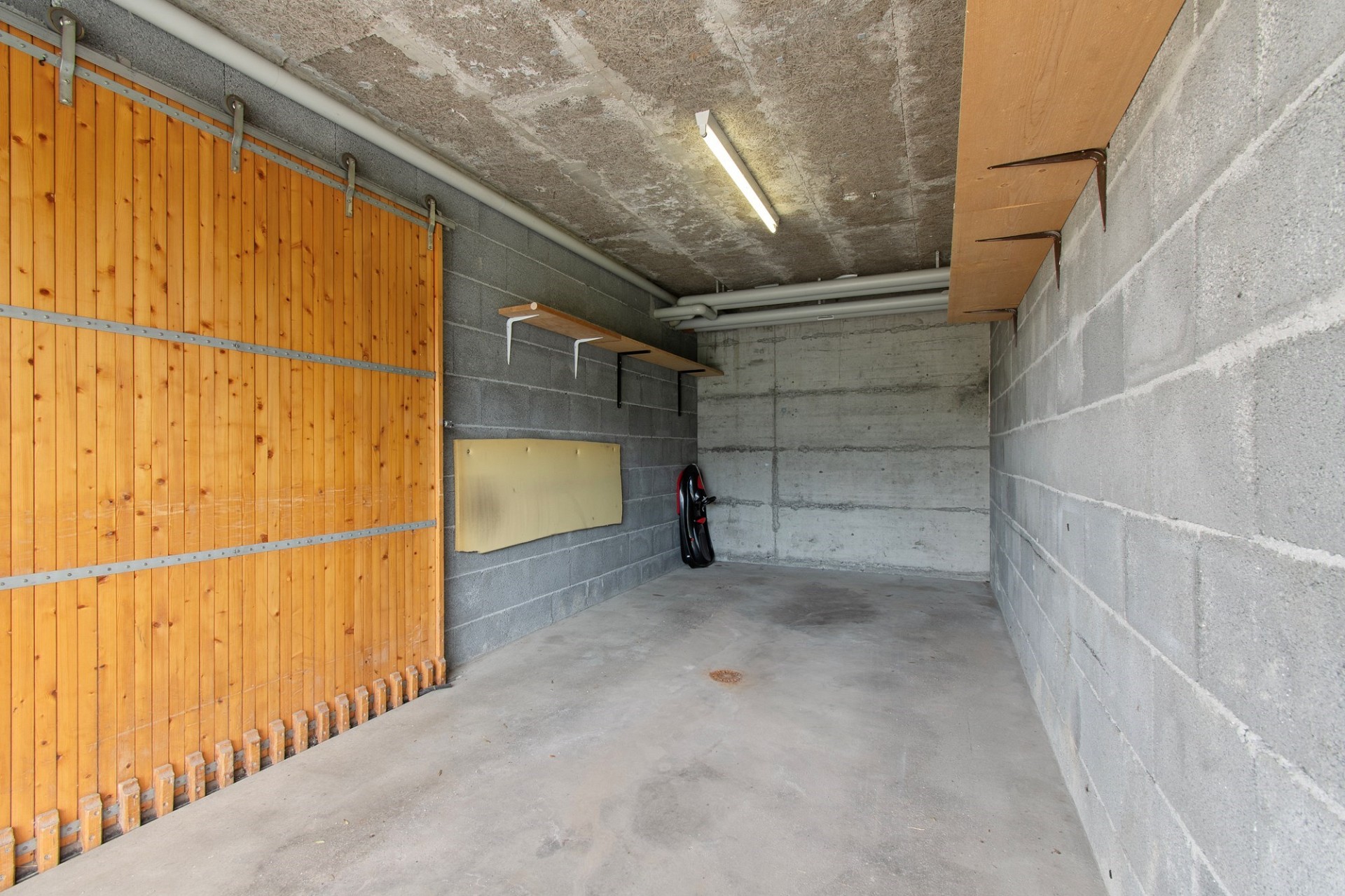 Garage mit Betonwänden und Holzschiebetor