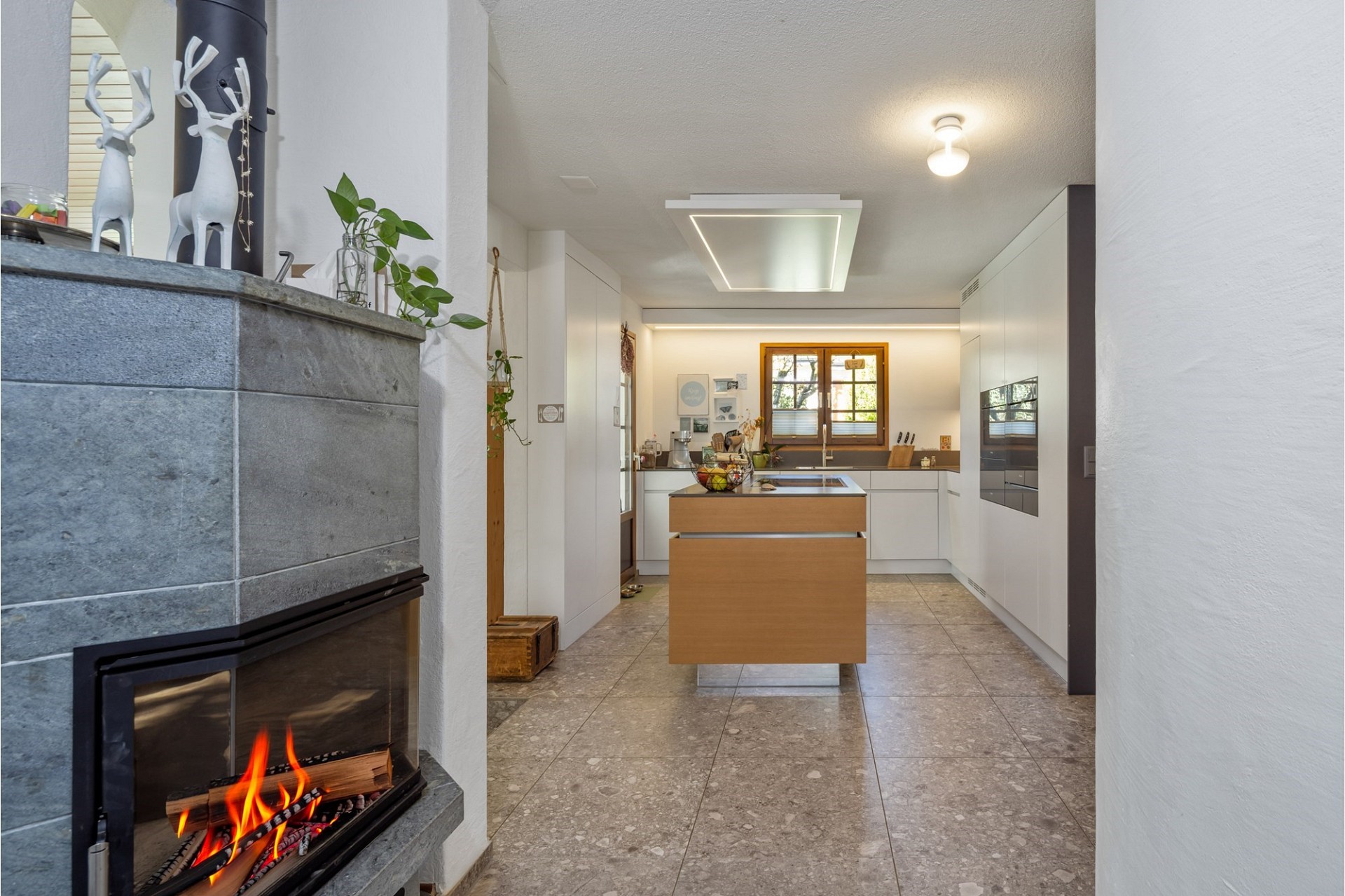 Moderne Küche mit Kamin und Kochinsel