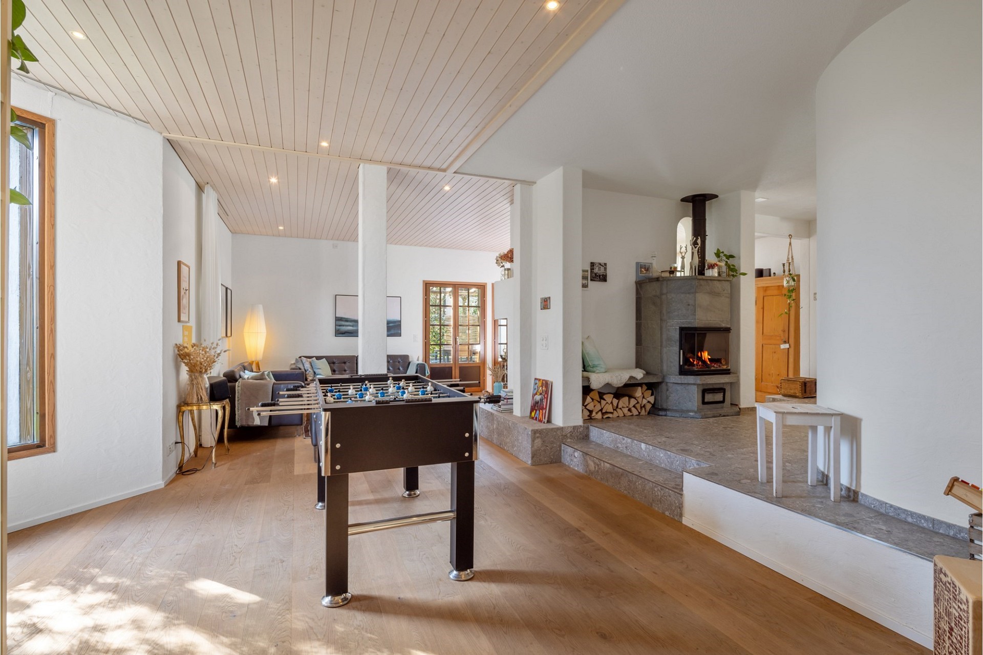 Heller Wohnraum mit Kamin und Tischkicker