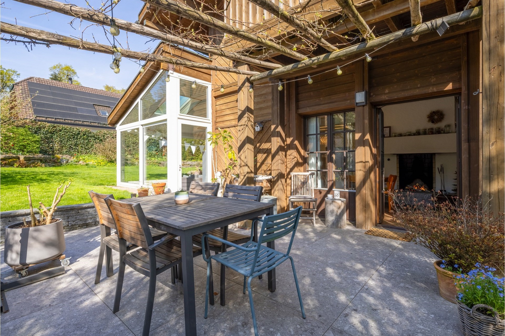 Gemütliche Holzterrasse mit Essbereich und Gartenblick