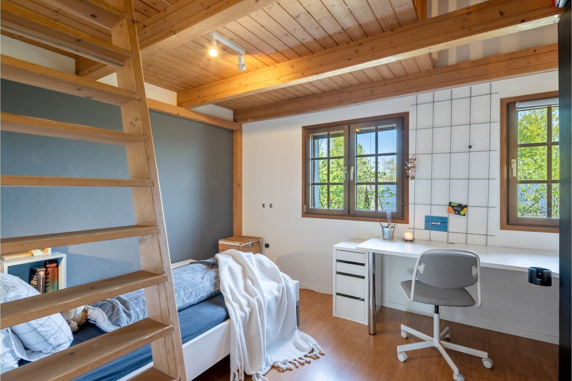 Helles Schlafzimmer mit Holzdecke und Schreibtisch