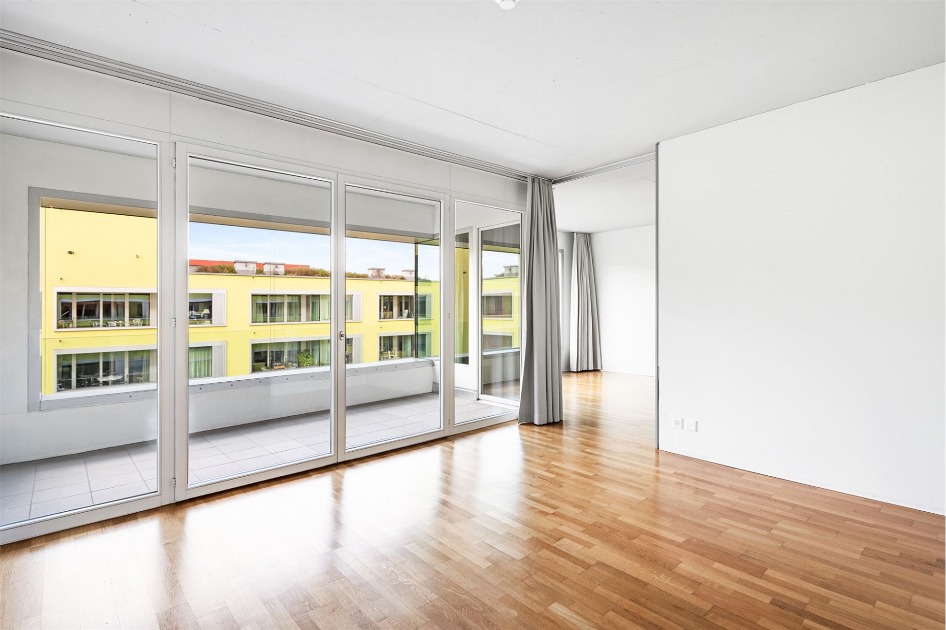 Helles Wohn- oder Schlafzimmer mit Balkon