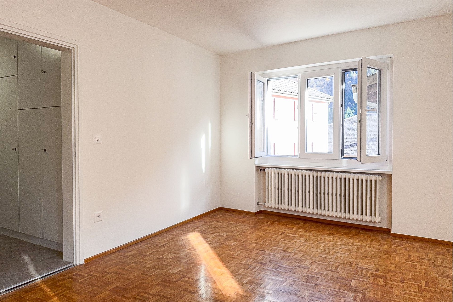 Leerer Raum mit Parkett und Fenster