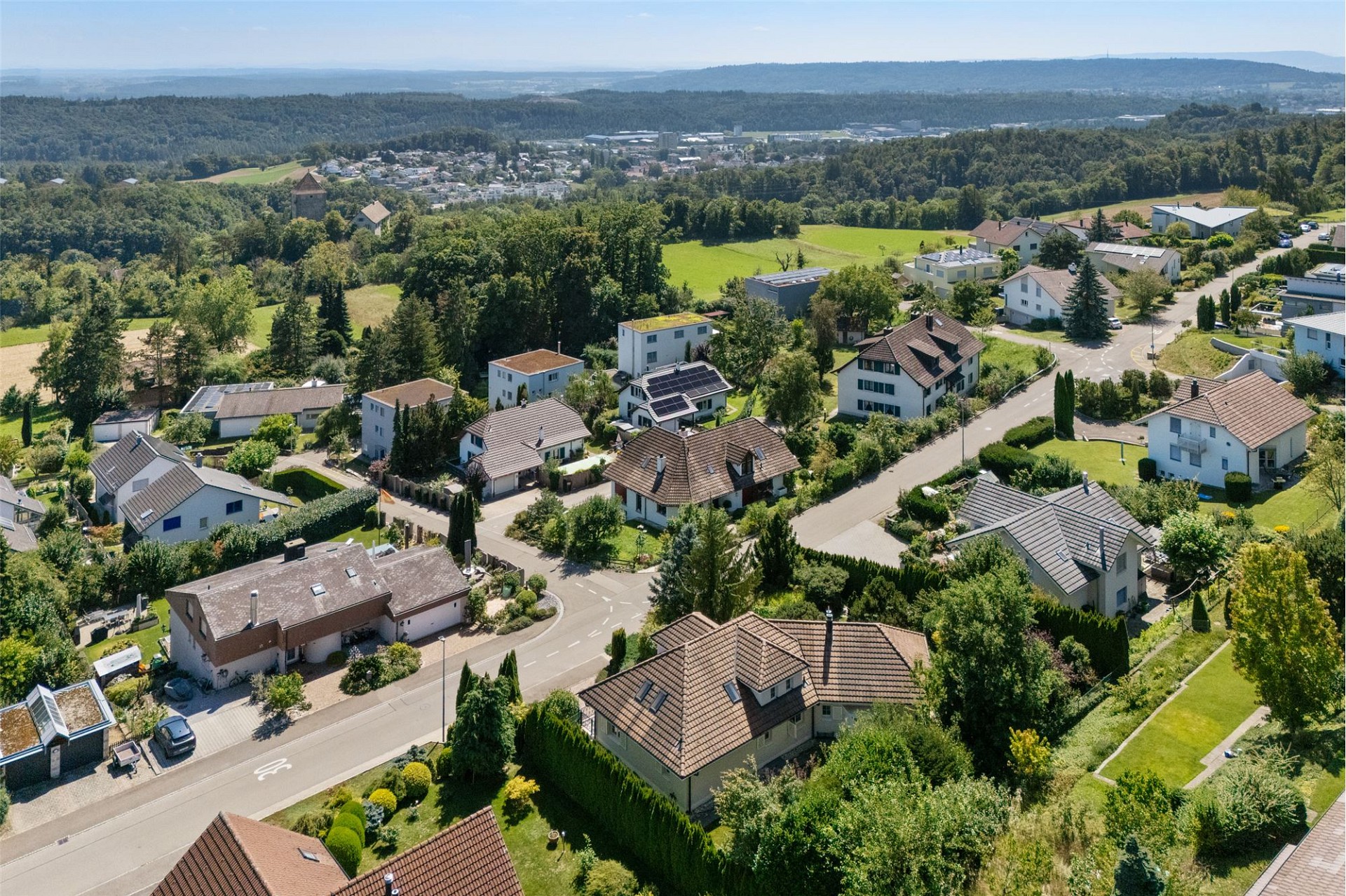 Luftaufnahme eines grünen Wohnviertels mit Blick ins Tal