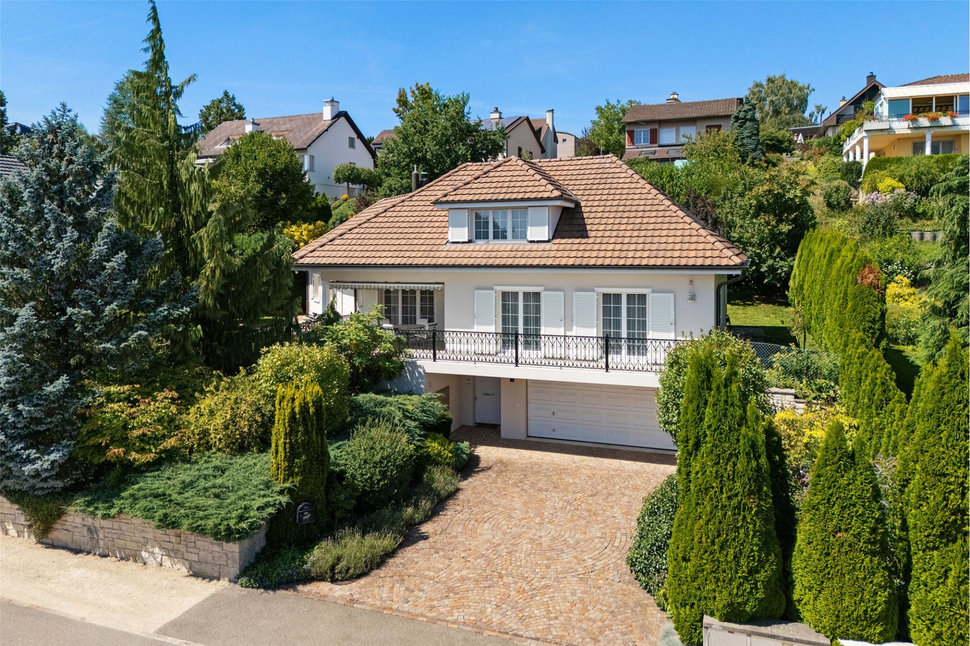 Einfamilienhaus mit mediterranem Ziegeldach und üppigem Garten