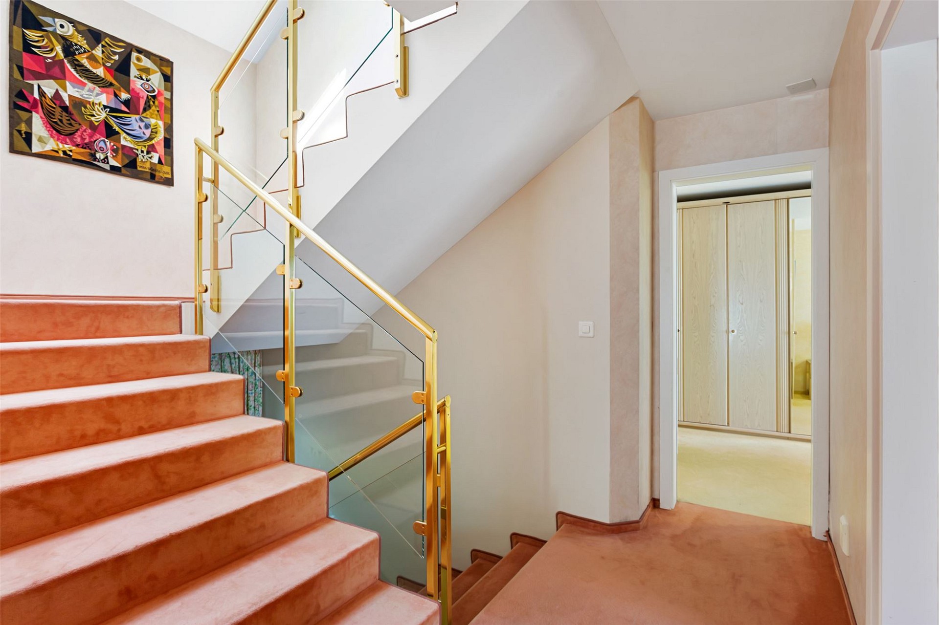 Treppenhaus mit goldfarbenem Geländer